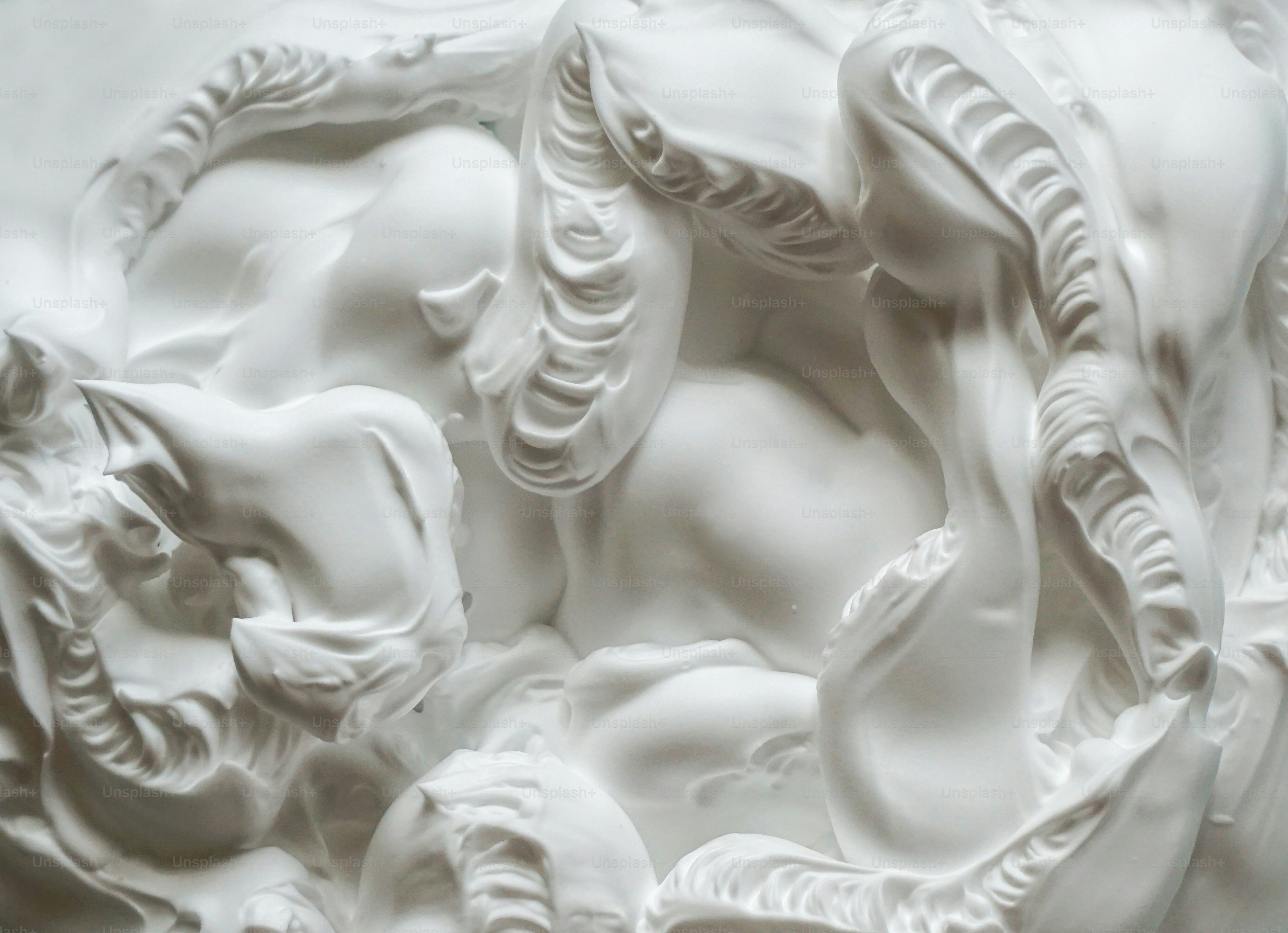 Detailed white relief sculpture of intertwined animals.
