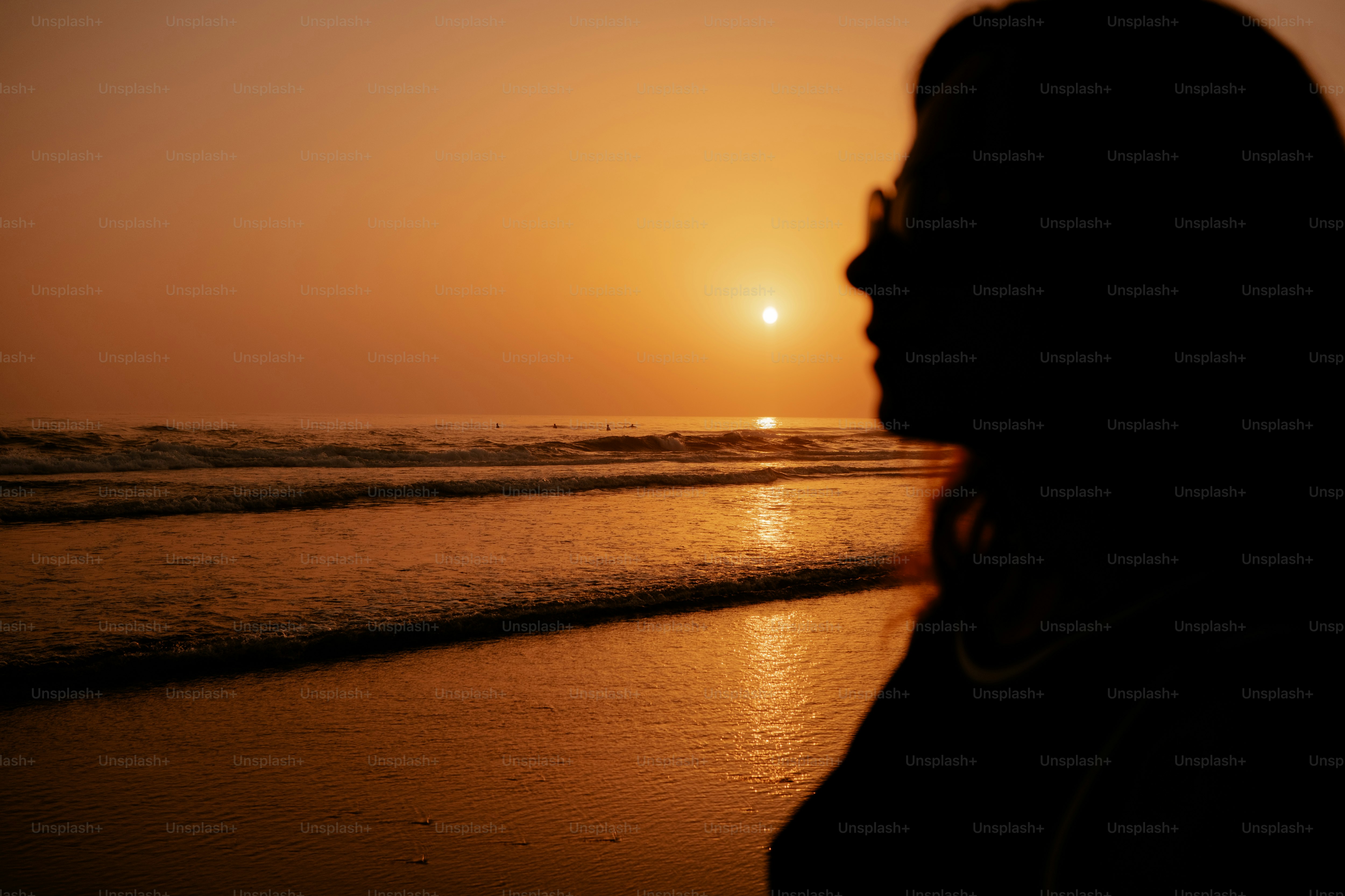 Woman watches the sunset over the ocean