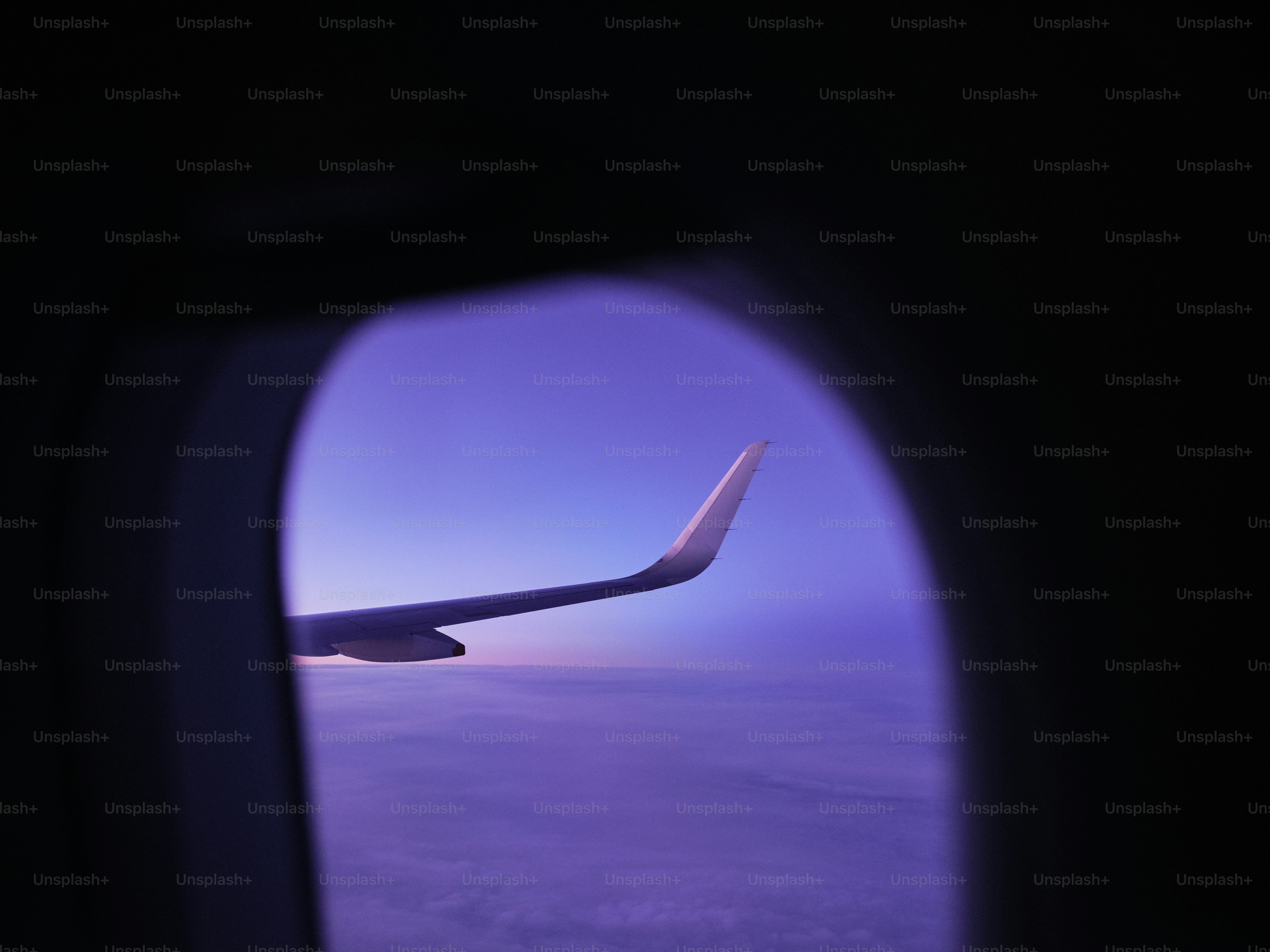 Airplane wing seen through window at twilight