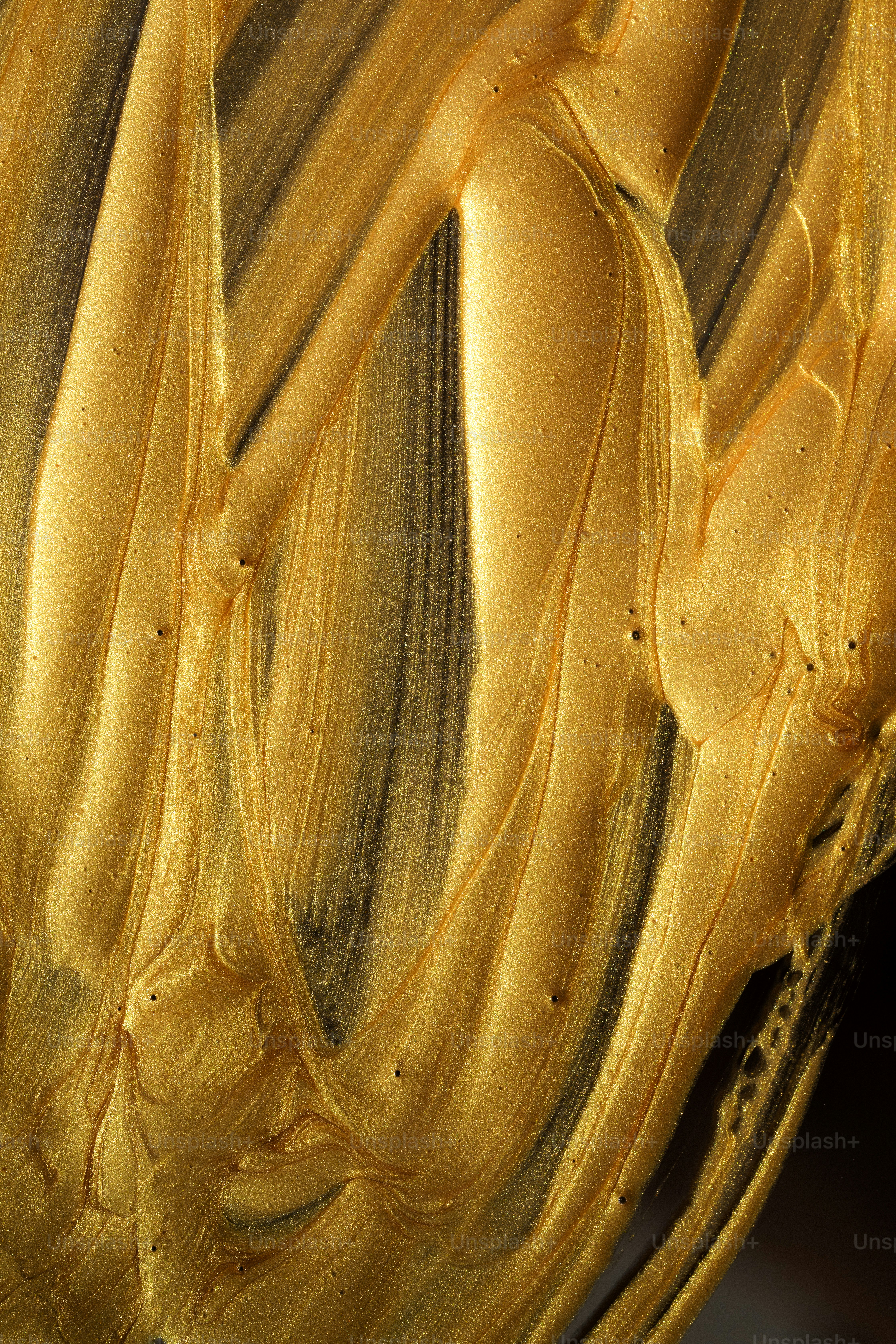 Gold paint strokes create an abstract design.