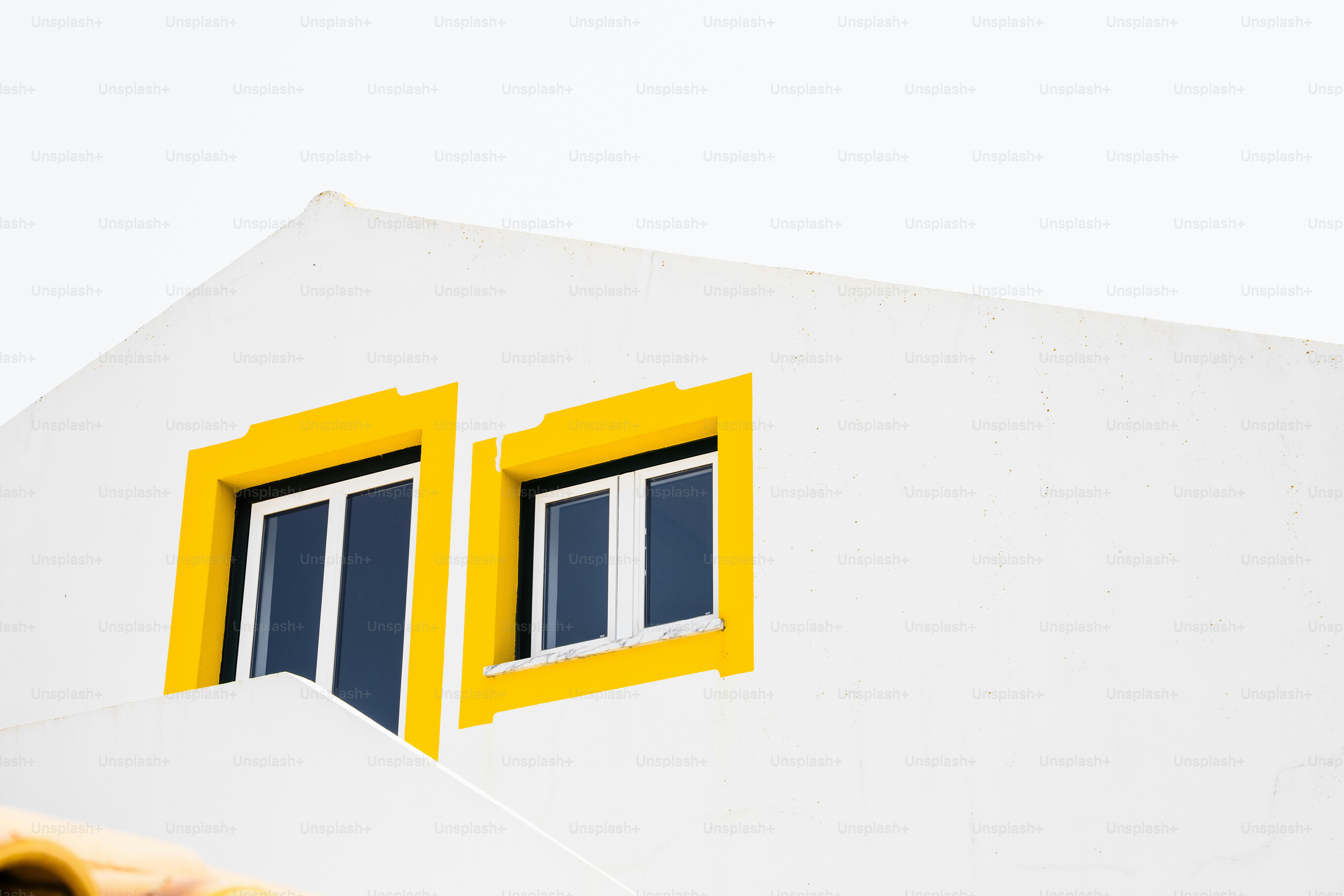 White building with yellow window frames and windows. photo – House ...