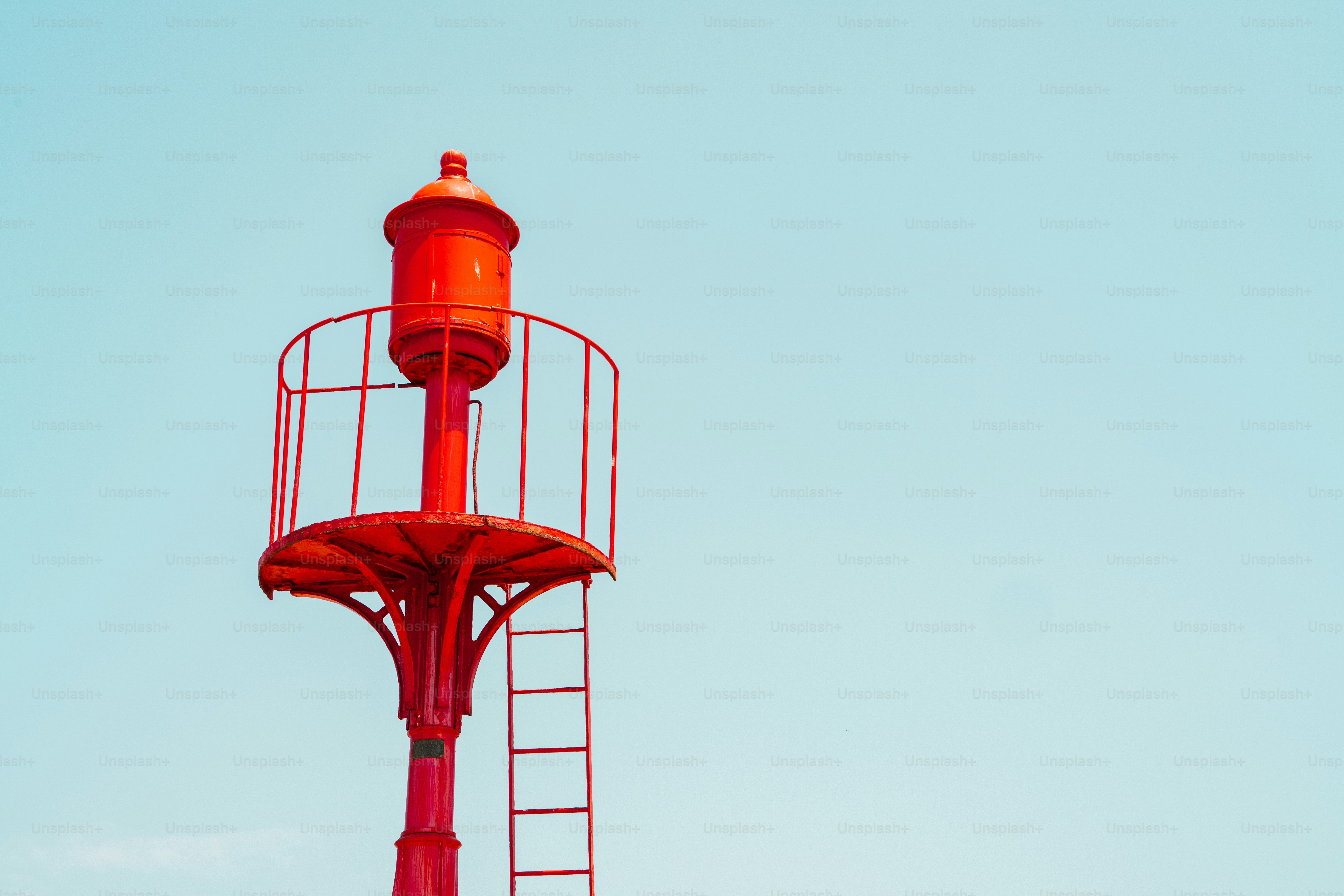 Red lighthouse against a clear blue sky