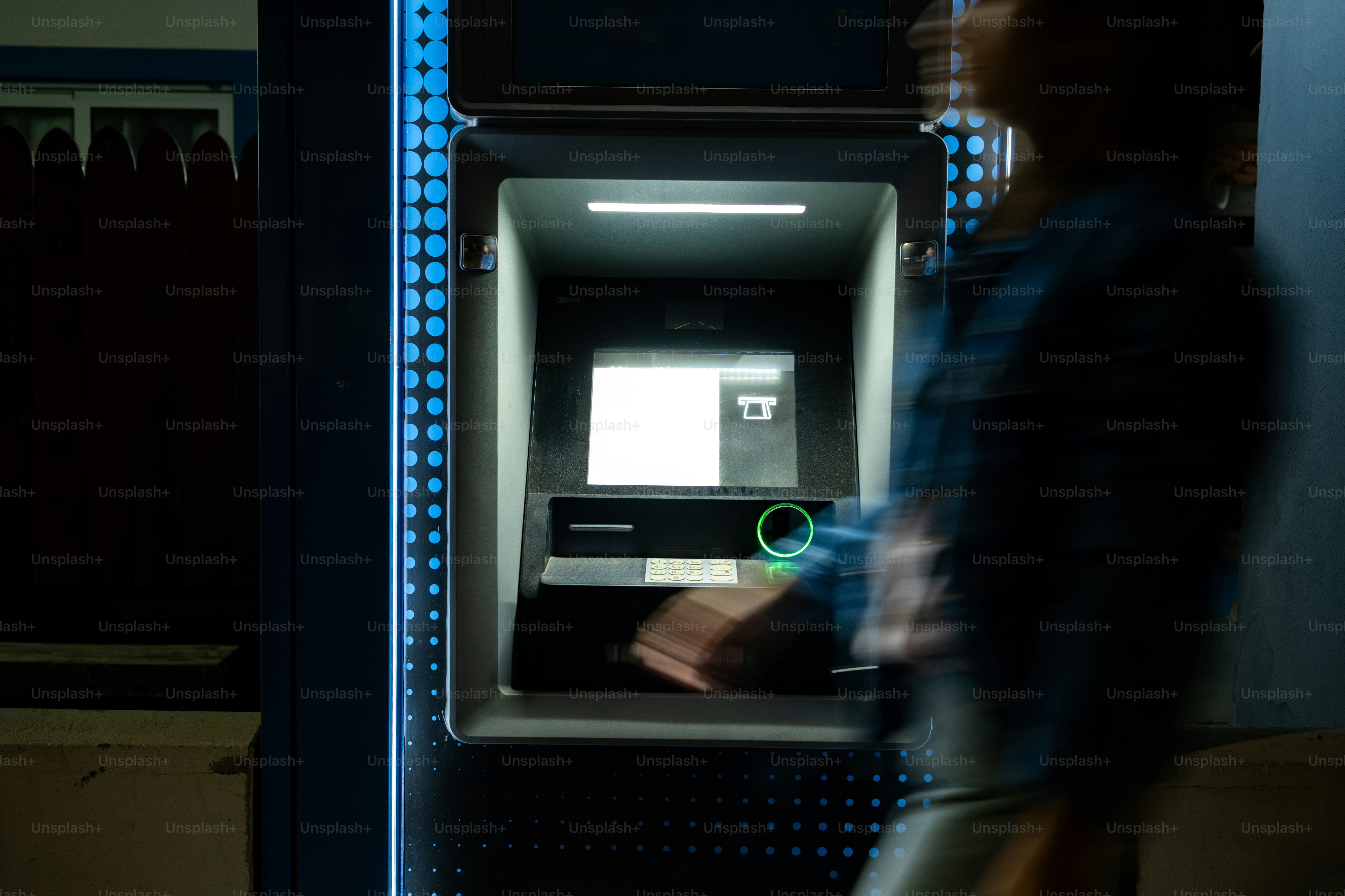Person using an atm at night
