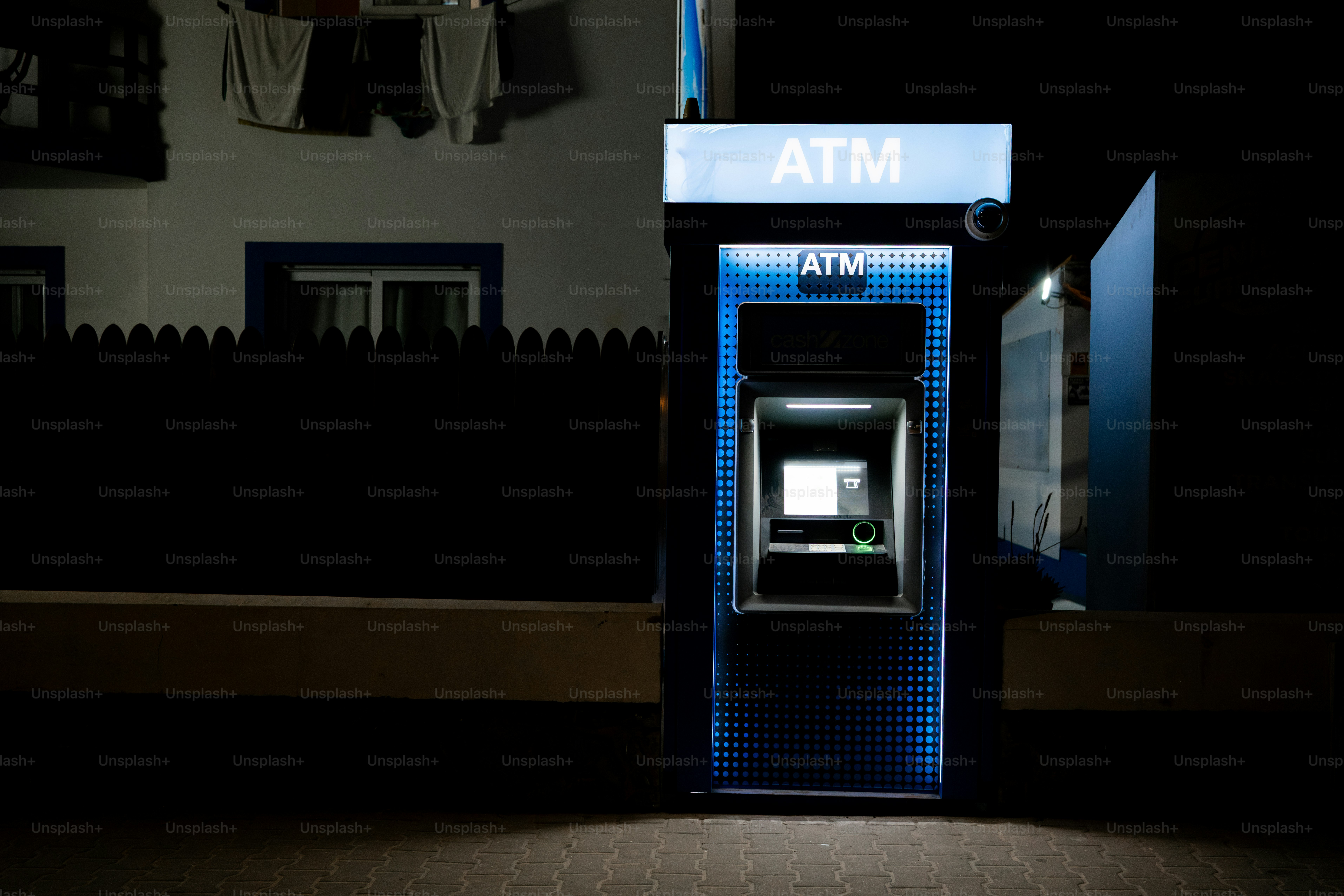 Woman using an atm on a blue wall photo – Money Image on Unsplash