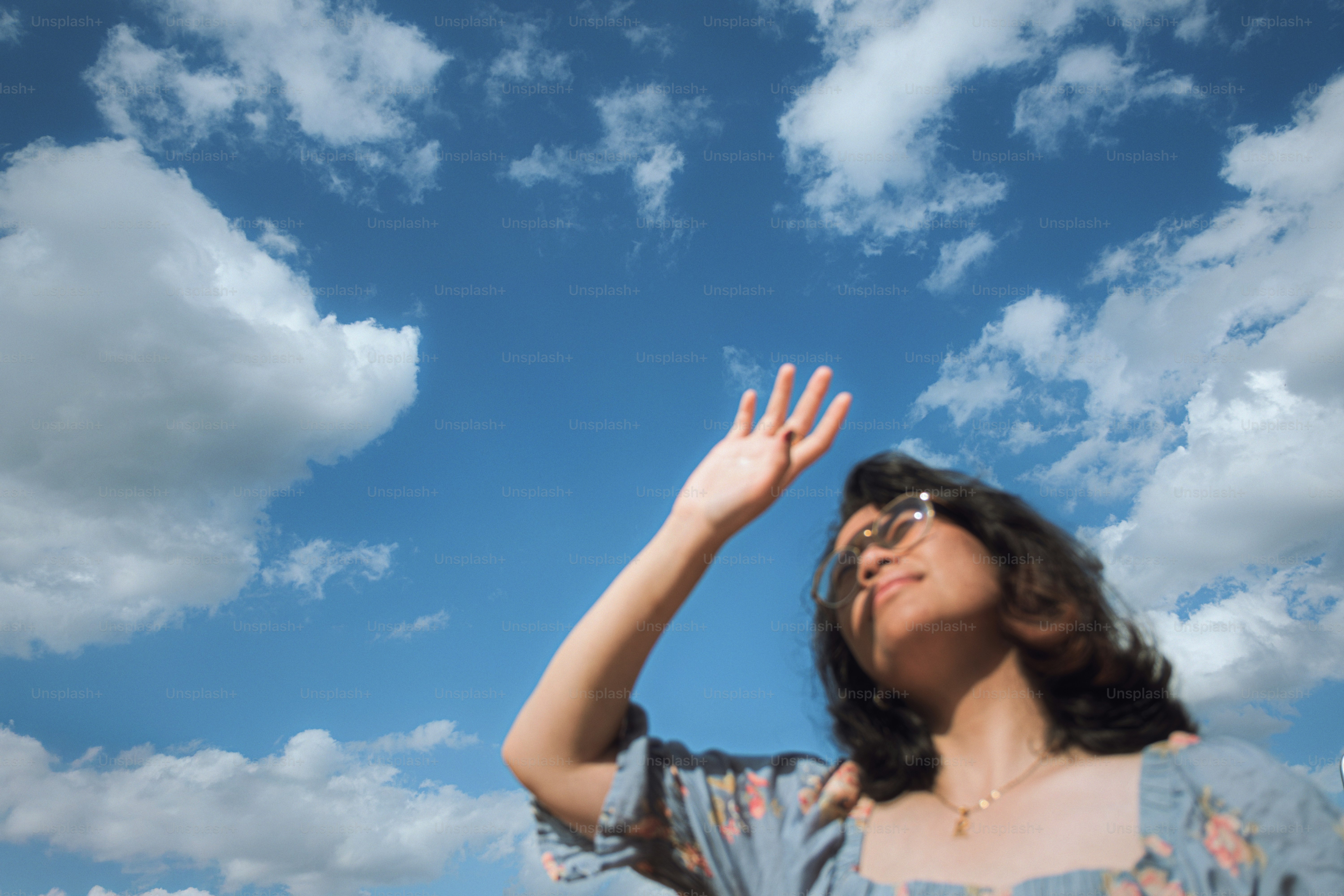 Donna che protegge gli occhi dal sole contro il cielo nuvoloso