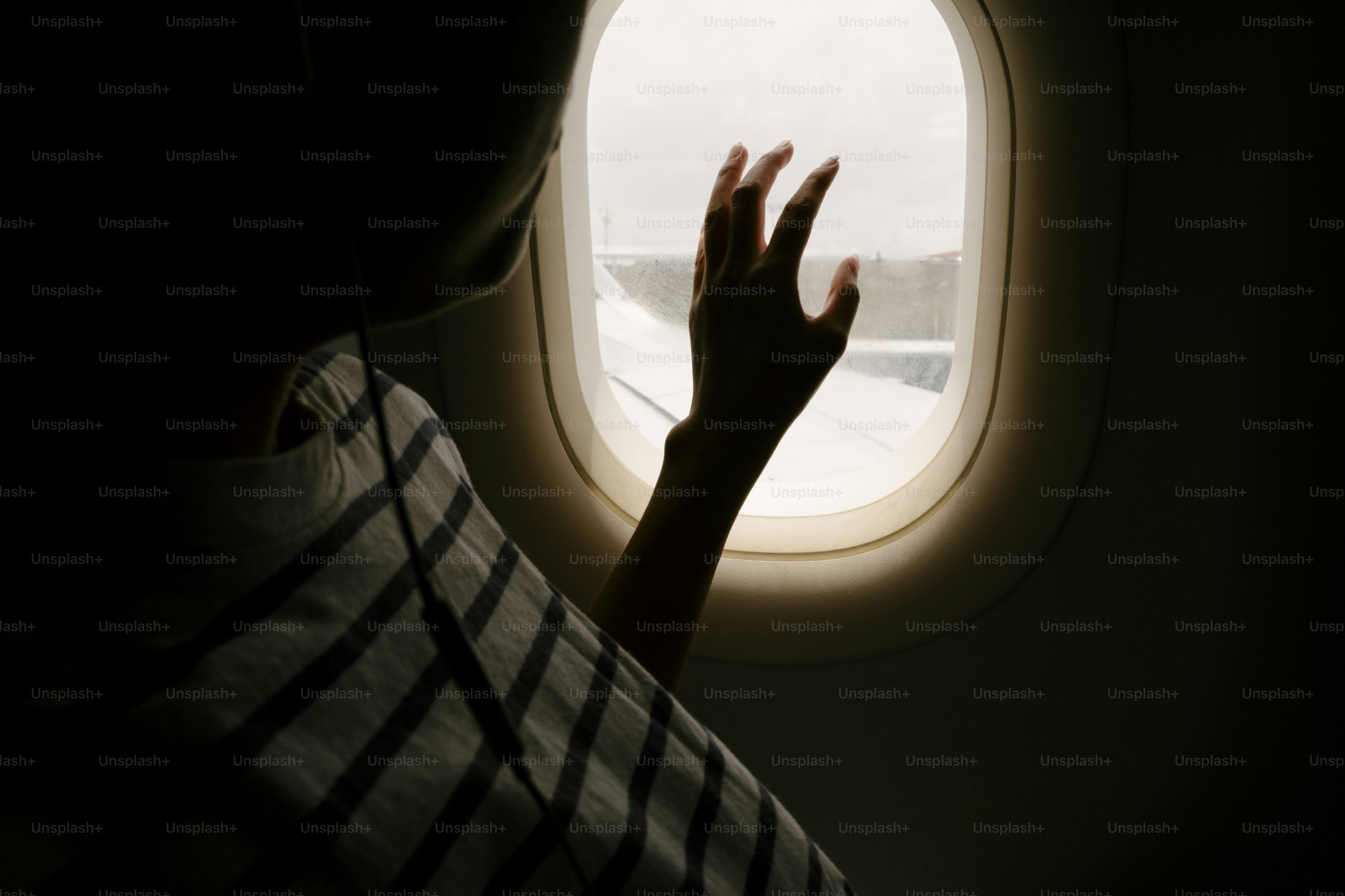 Person looking out airplane window