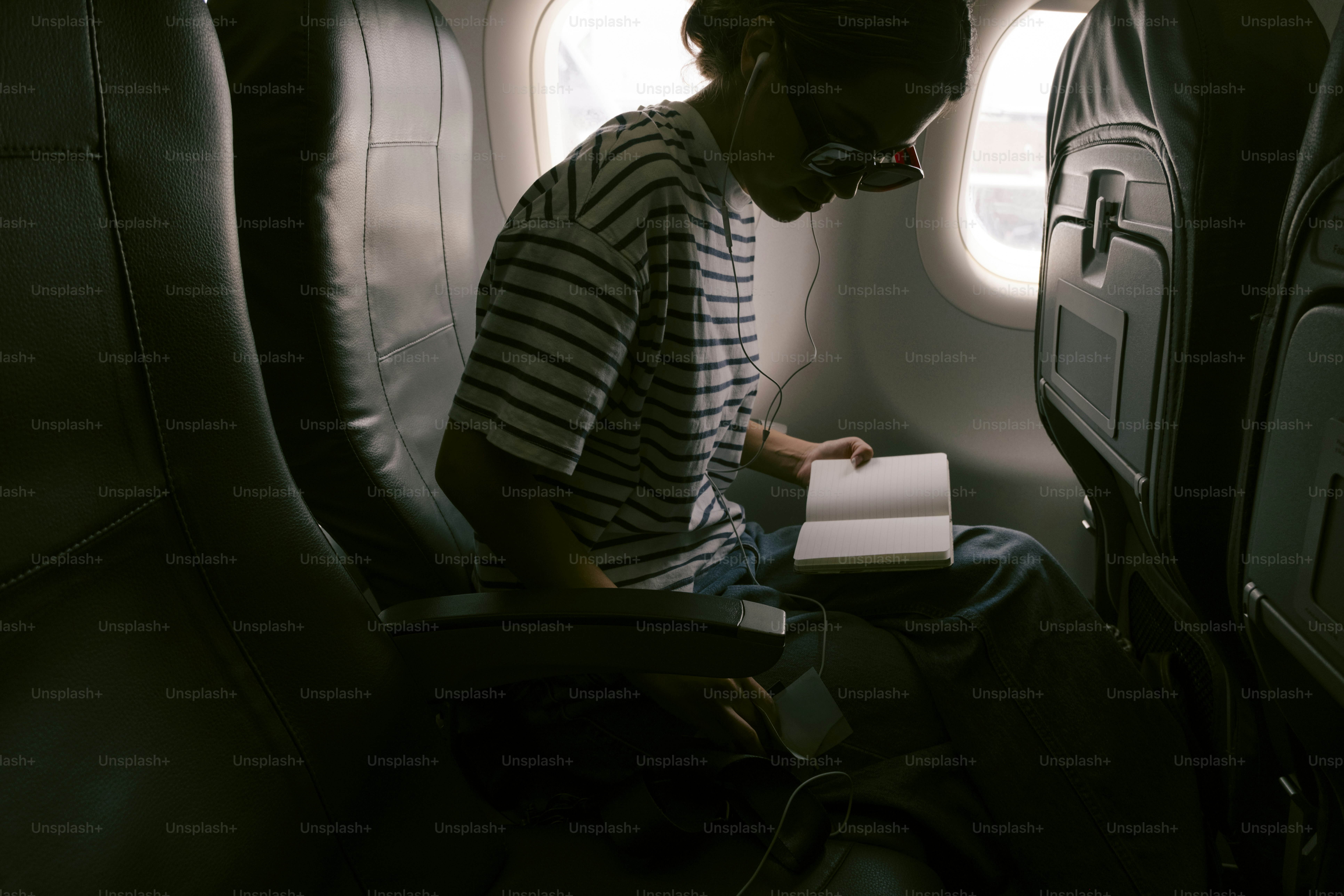 Pessoa lendo um livro em um avião.