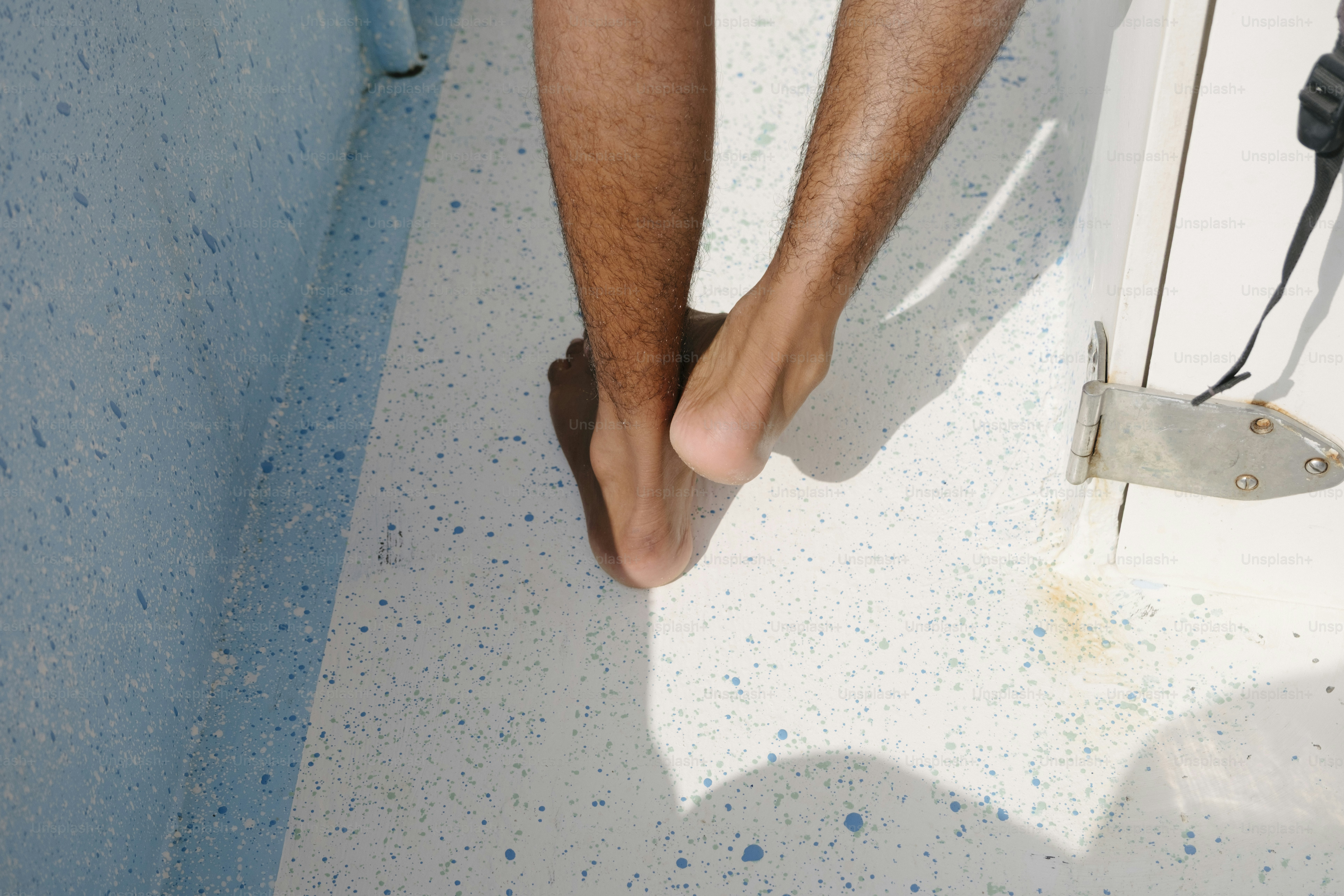 Die nackten Füße einer Person auf einem gesprenkelten Boden