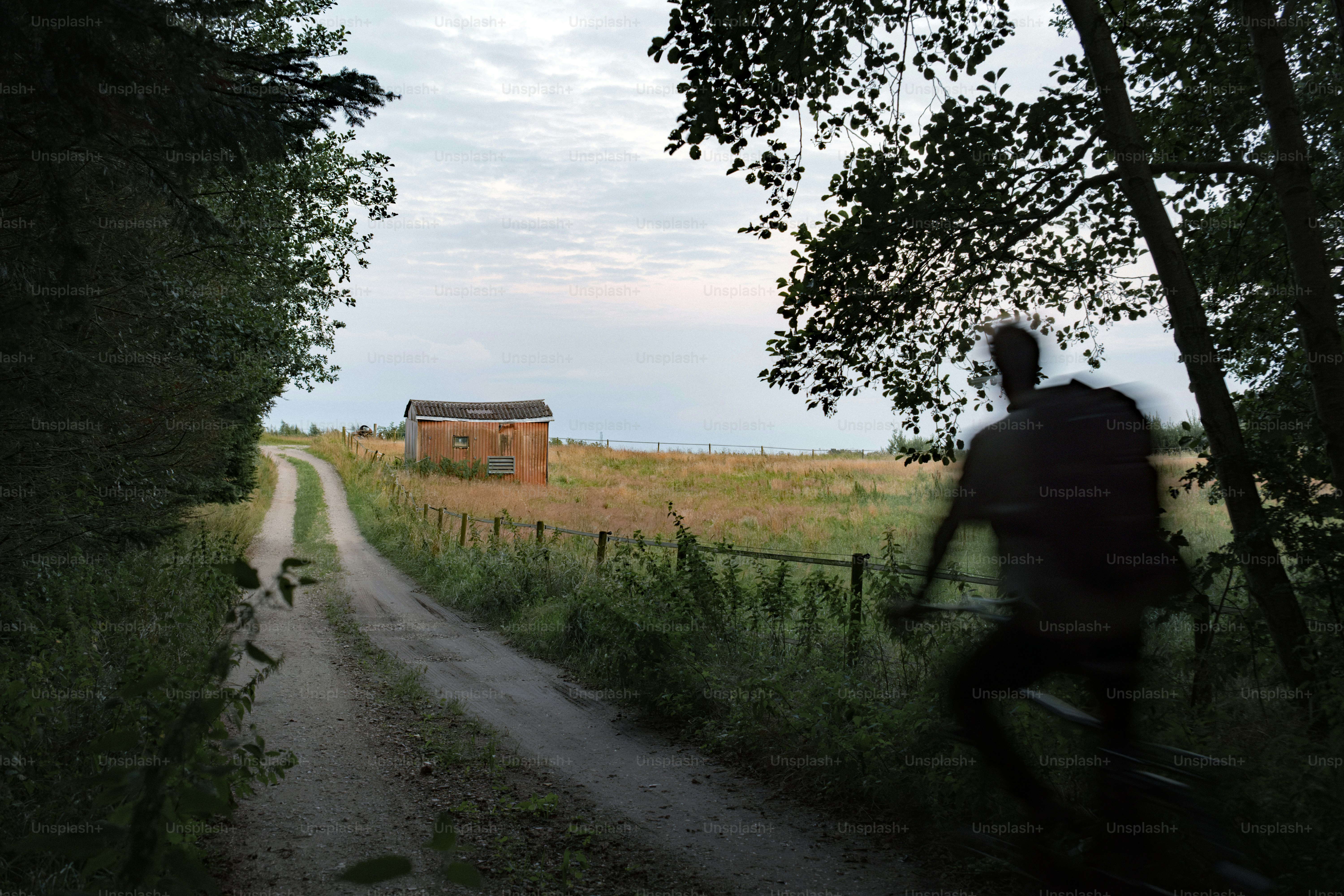 Persona che cammina su un sentiero verso un fienile