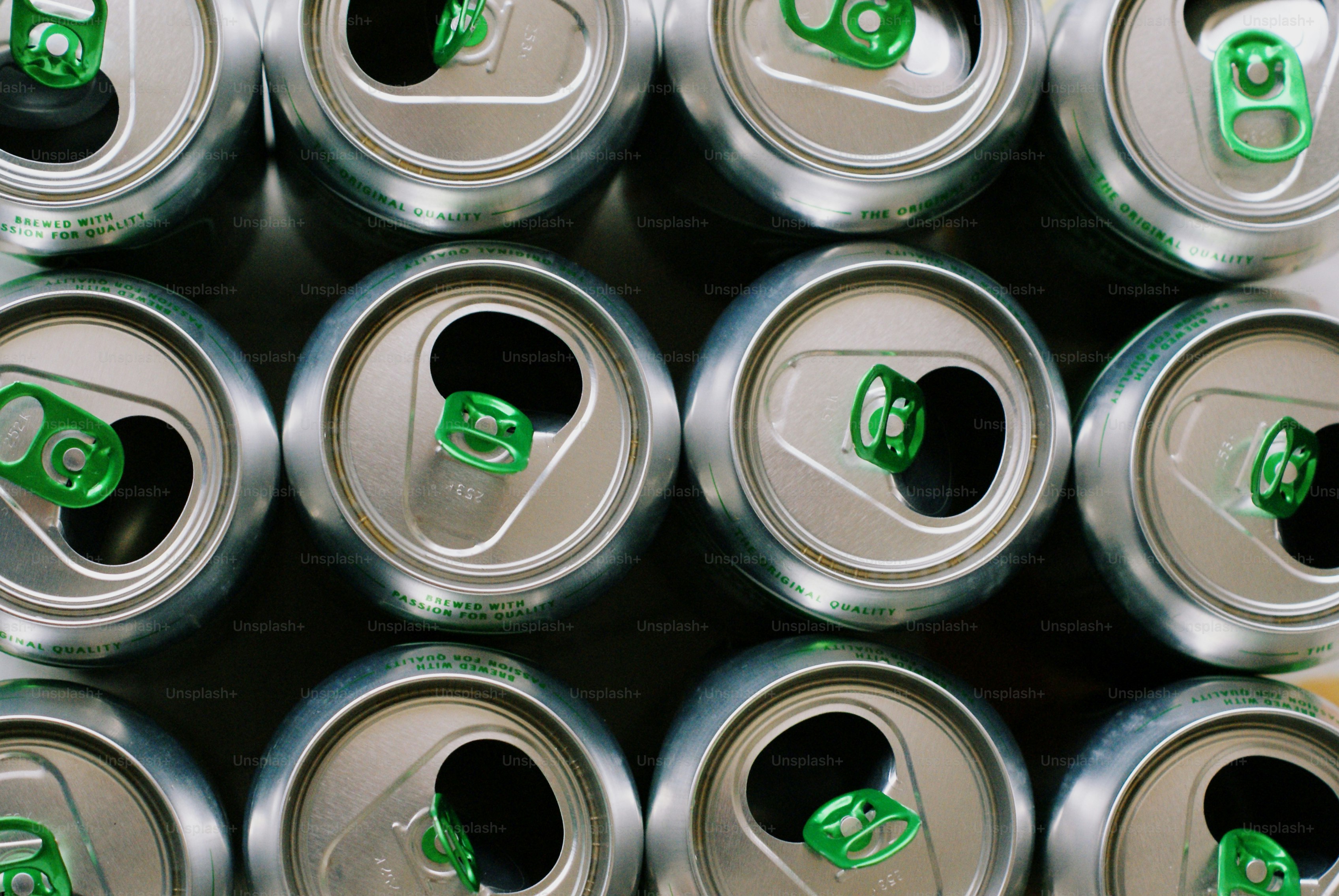 Rows of opened aluminum cans with green liquid