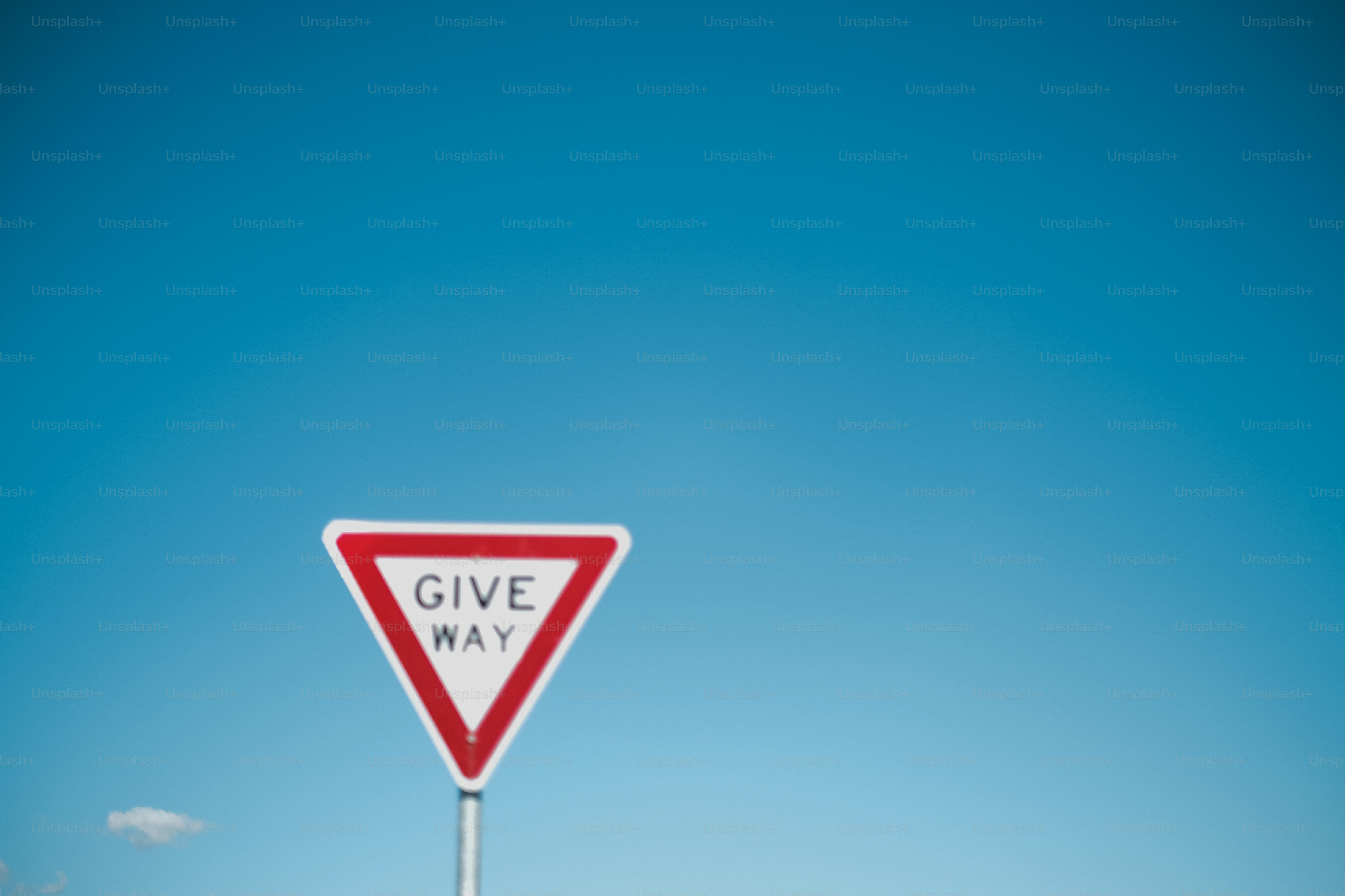 澄んだ青空を背景に道を譲る道路標識