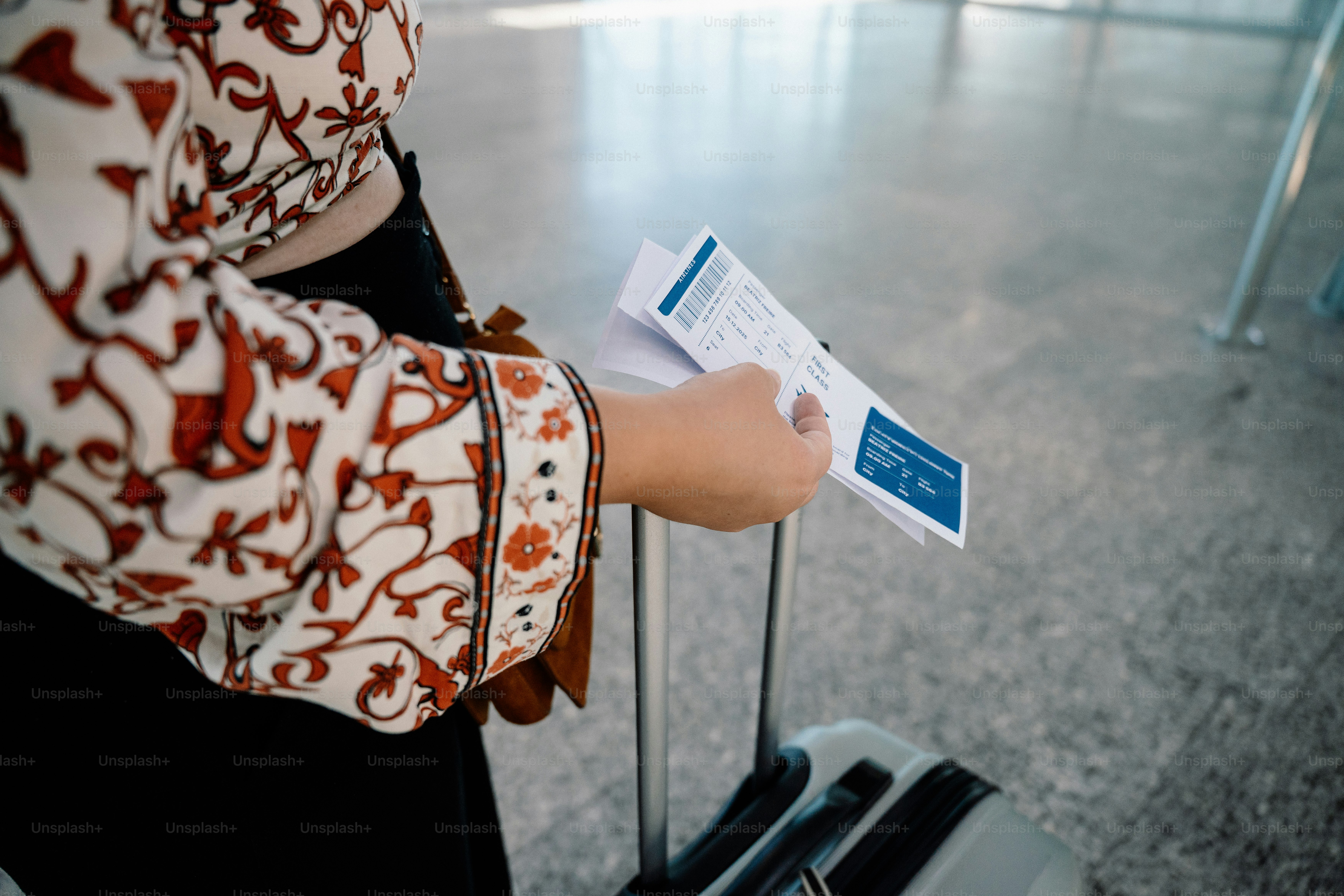Woman holding boarding pass near suitcase