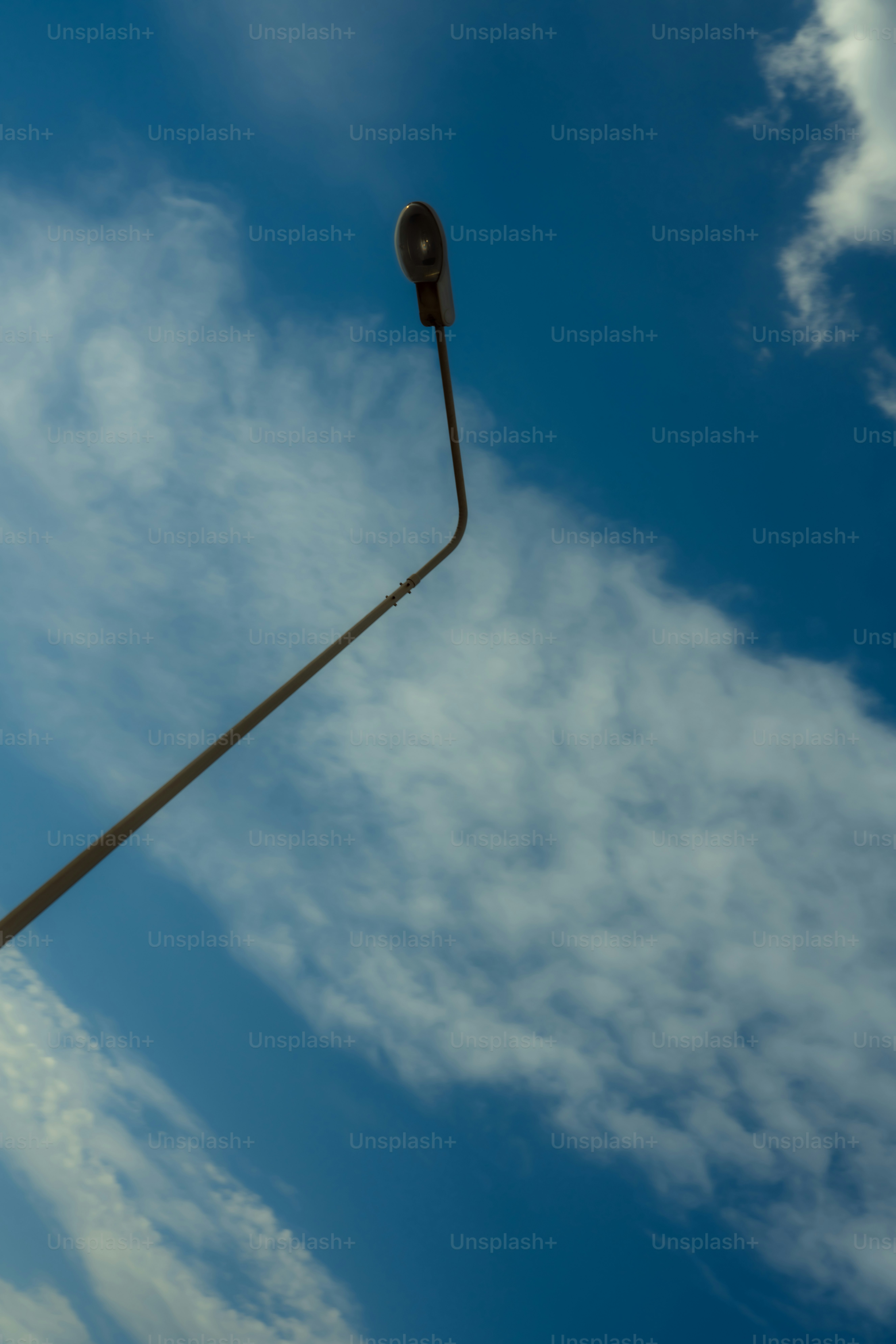 Lampadaire contre un ciel bleu vif avec des nuages