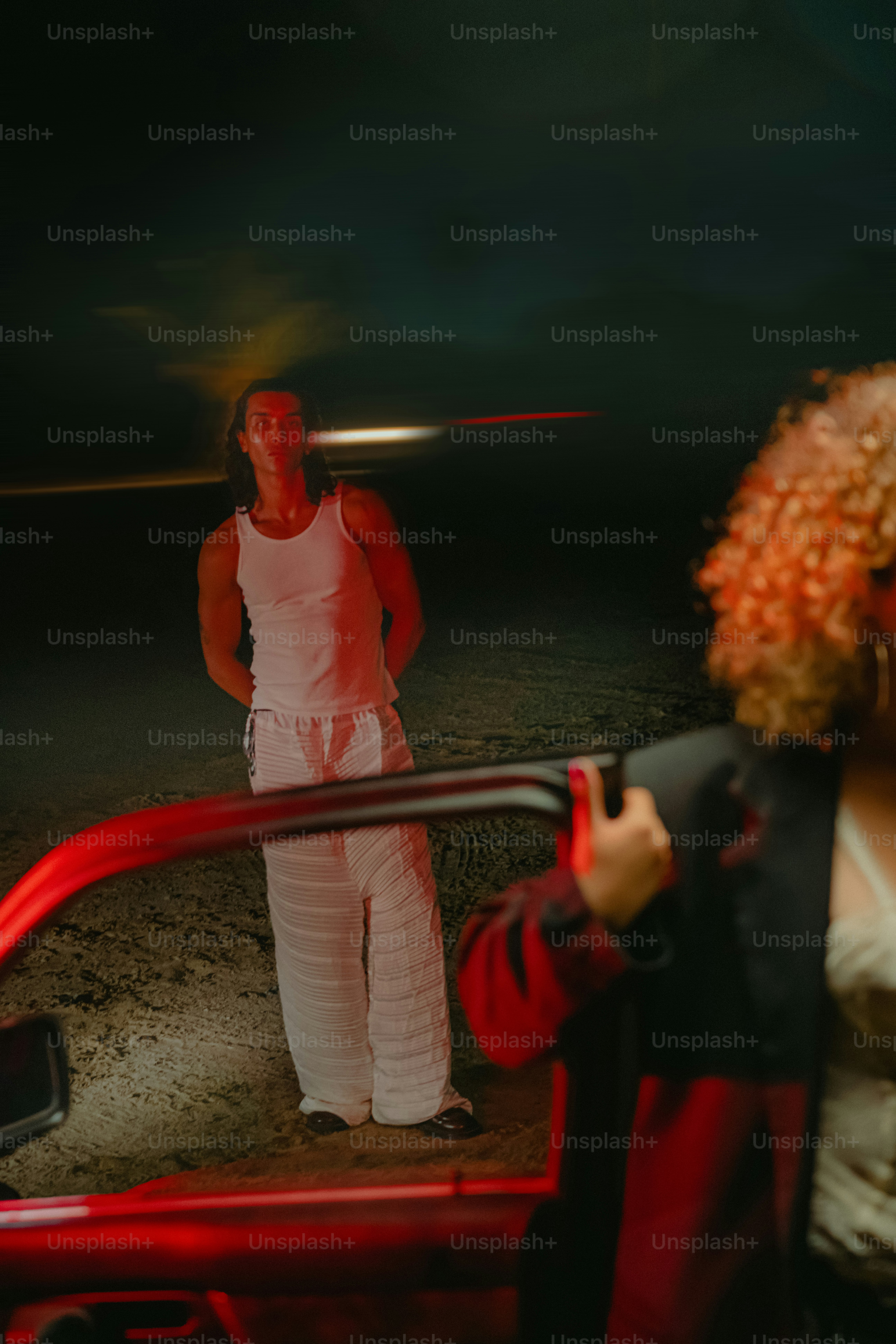 Dos personas cerca de un coche por la noche