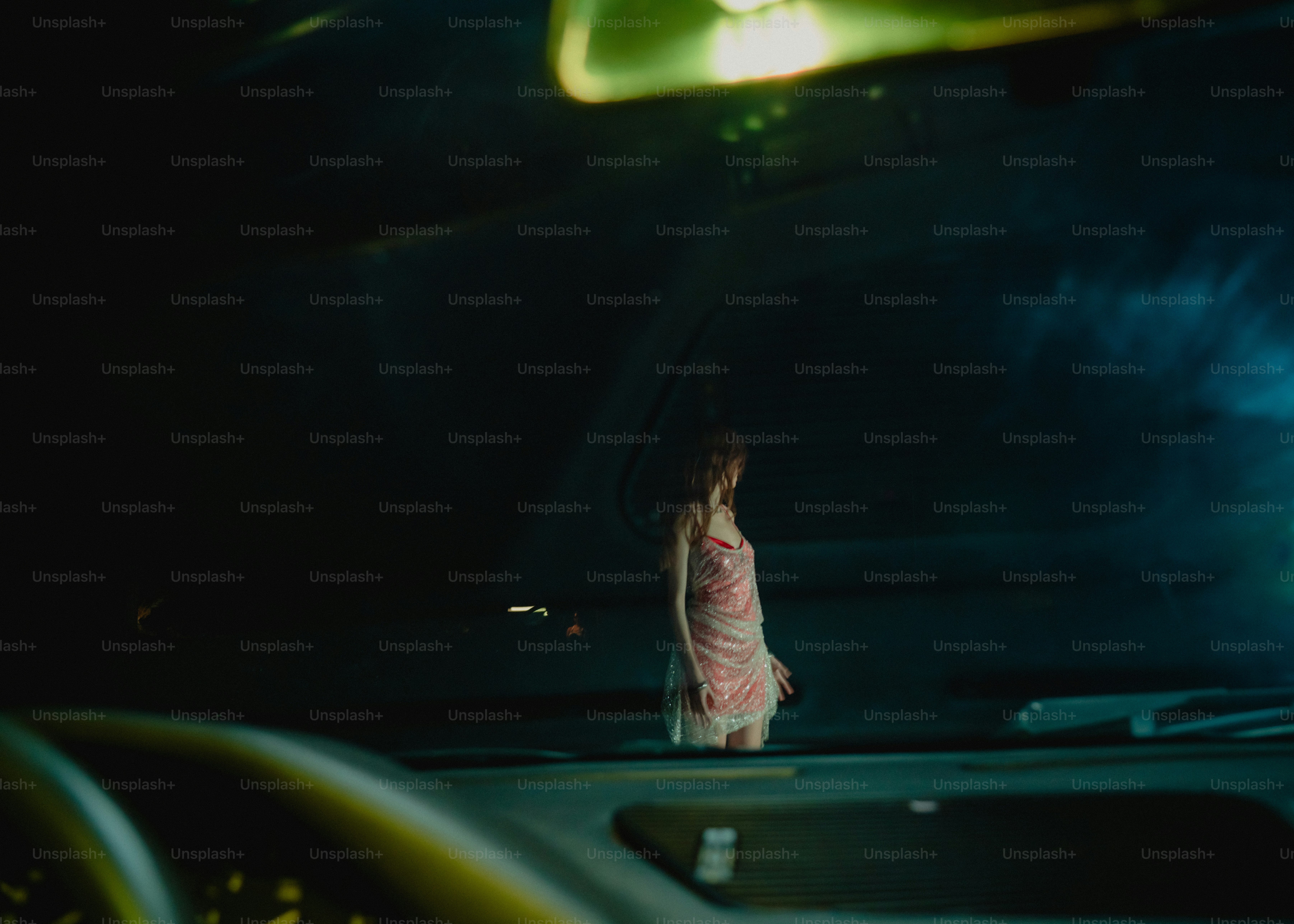 Mujer vestida de pie junto al coche por la noche