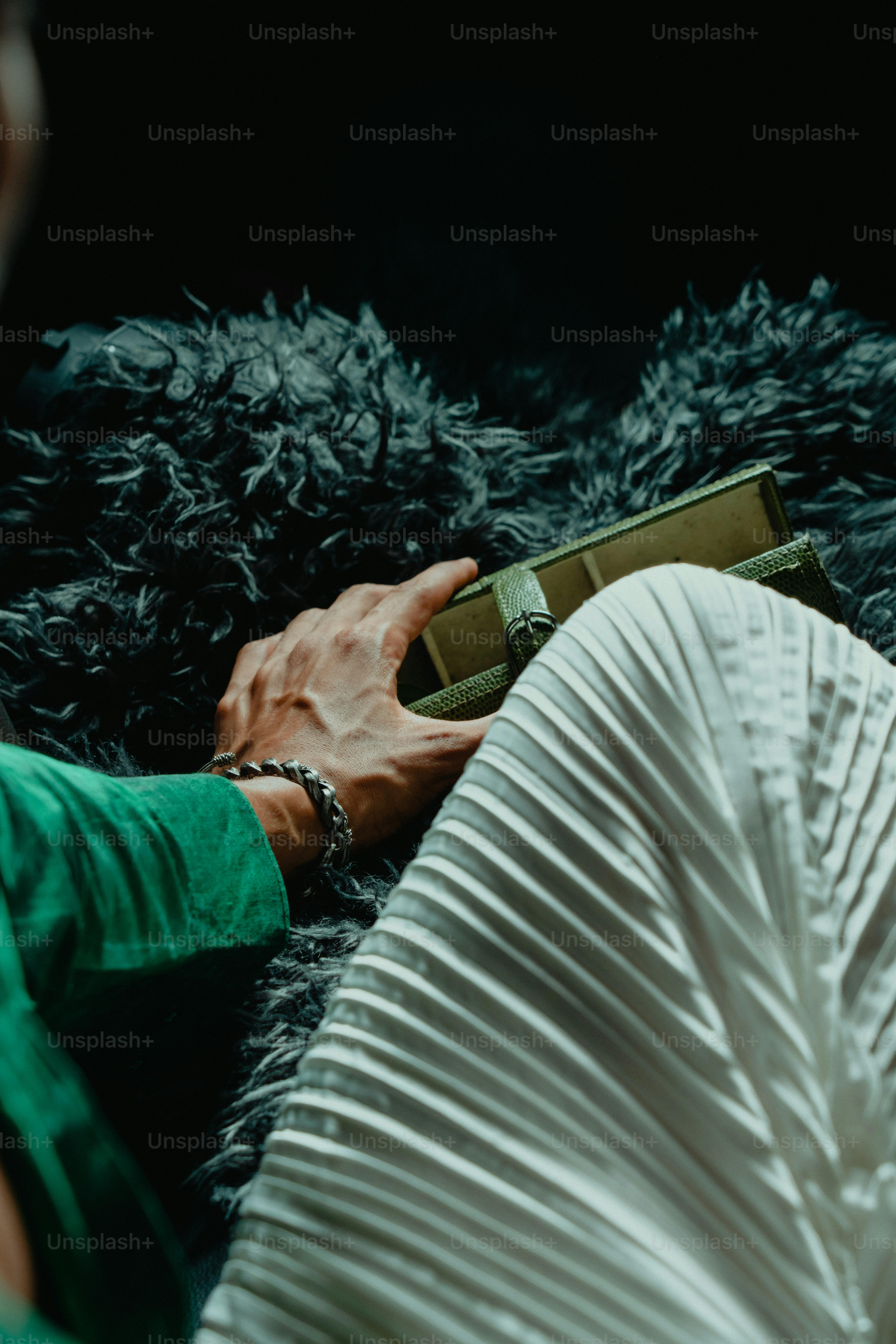 Persona sosteniendo un libro sobre una superficie peluda.