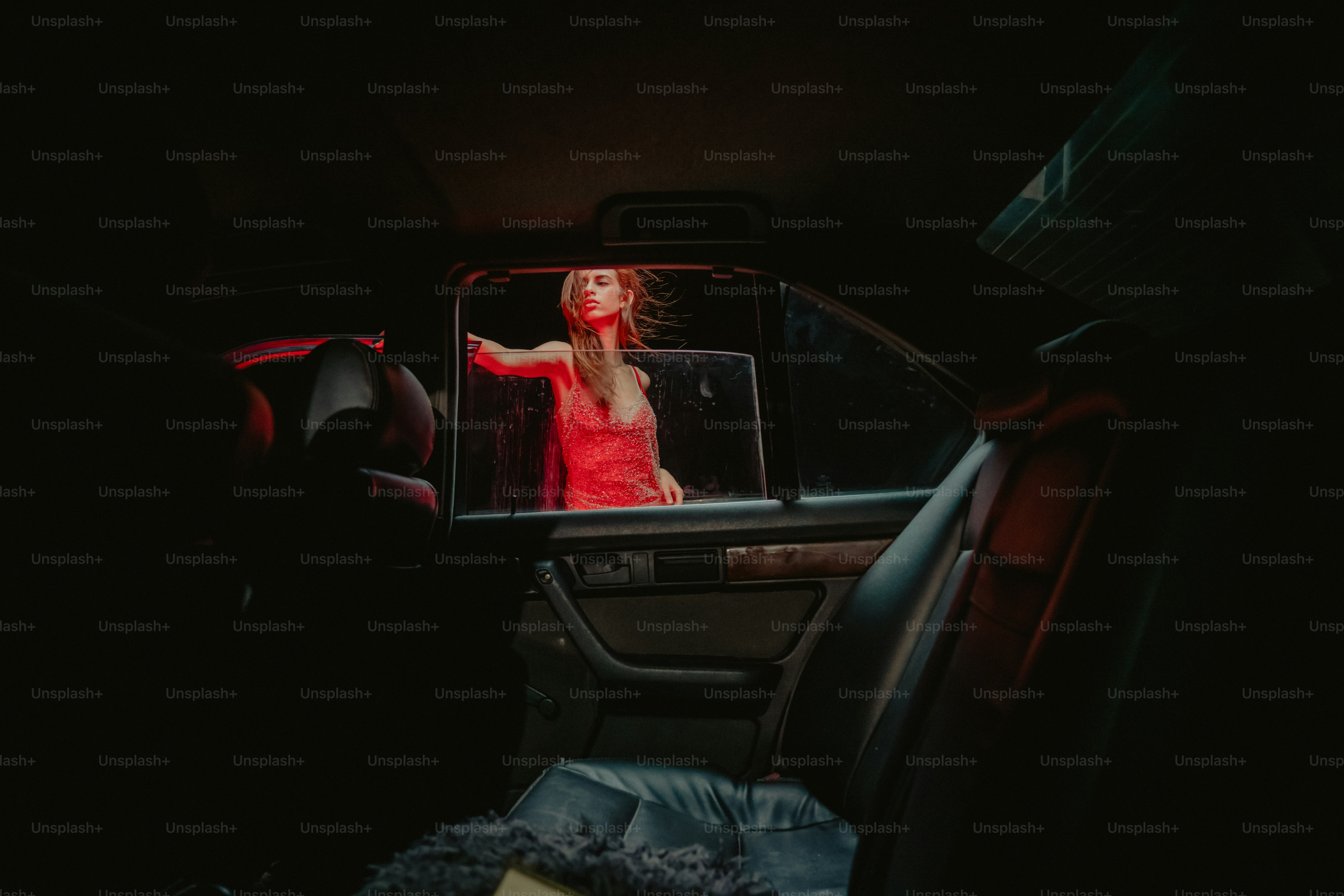 Mujer en un coche por la noche con luz roja