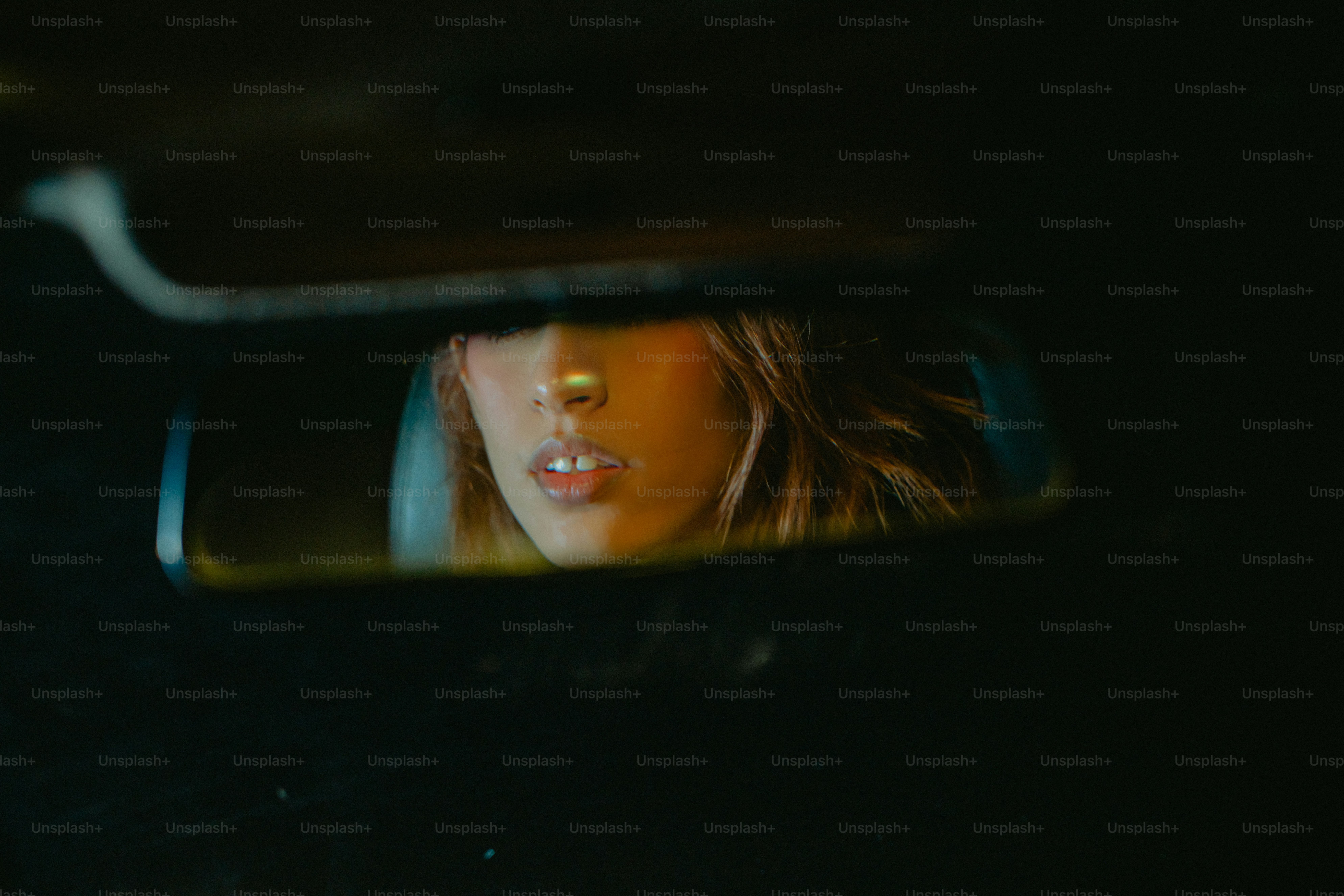 El rostro de una mujer reflejado en el espejo retrovisor de un automóvil