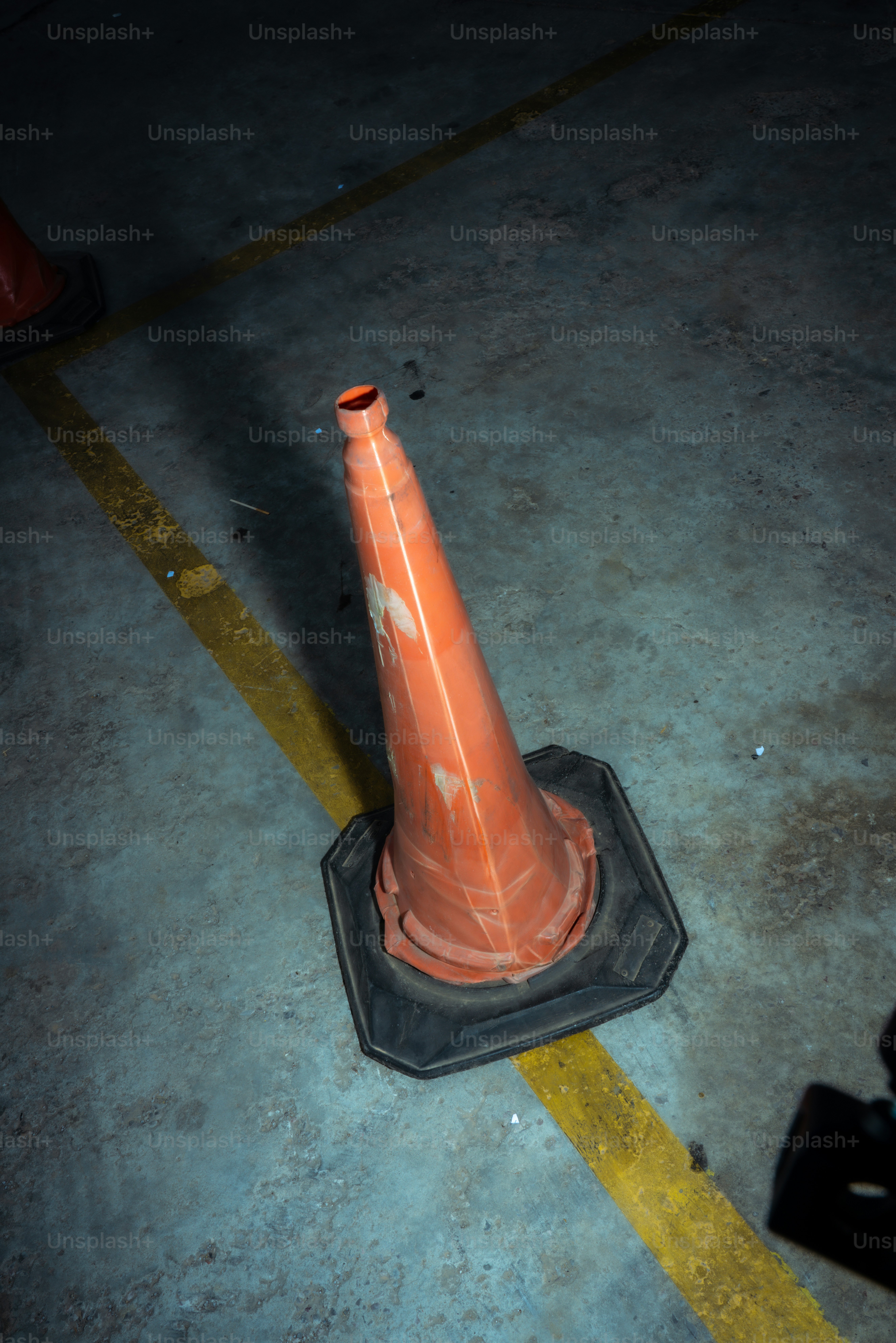 Cono de tráfico naranja en una línea amarilla