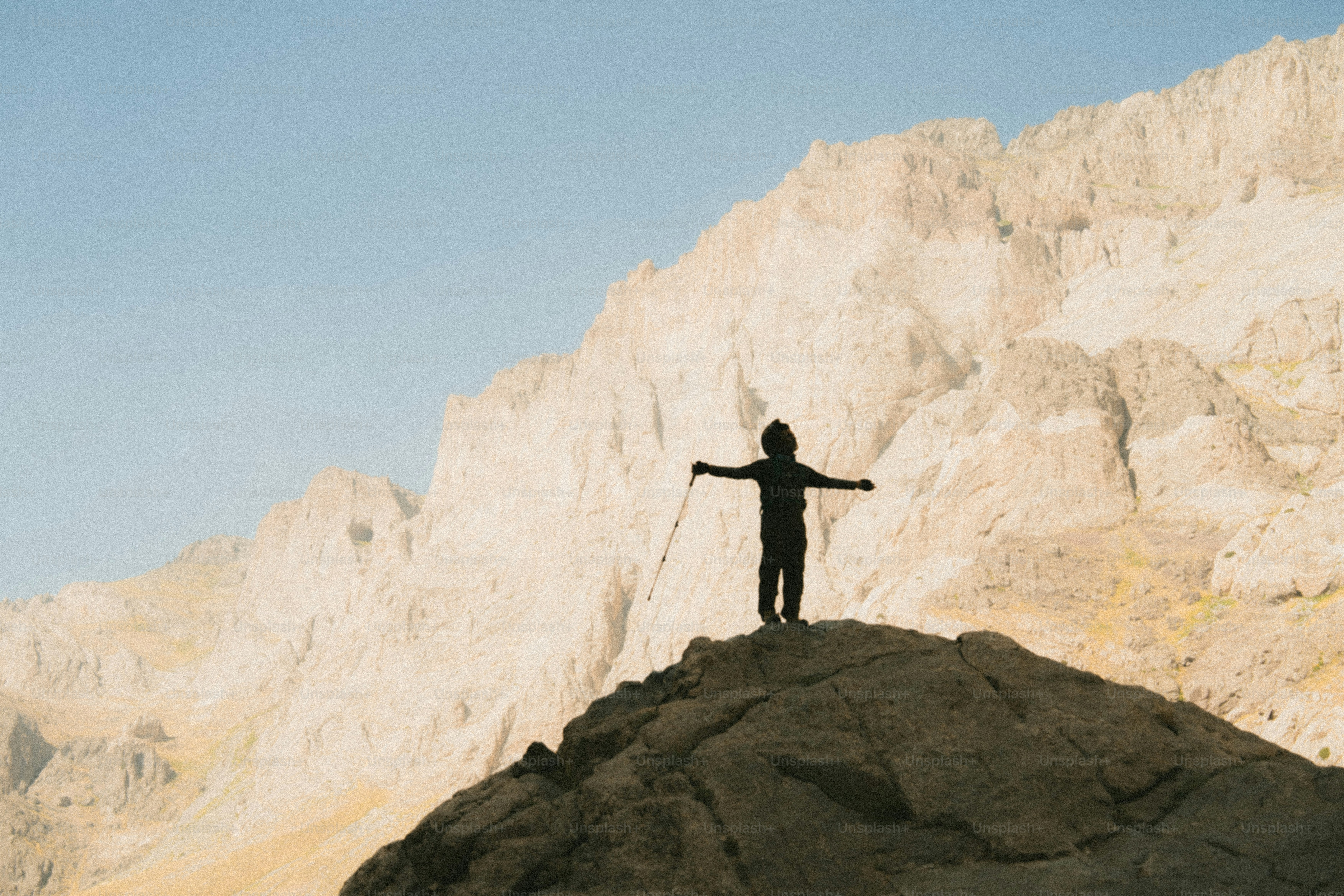 Hiker with arms outstretched on mountain peak