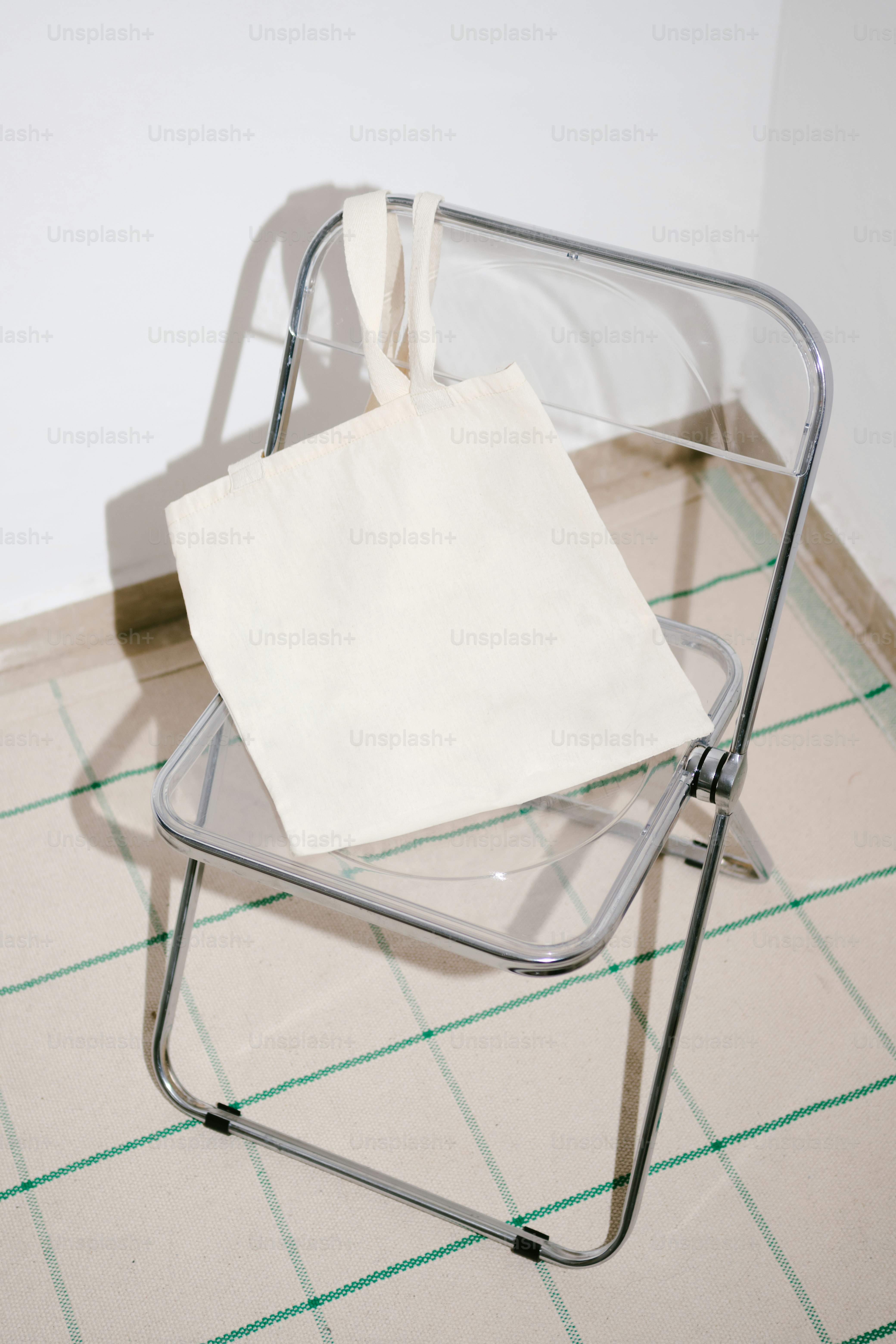 White tote bag on a transparent chair.
