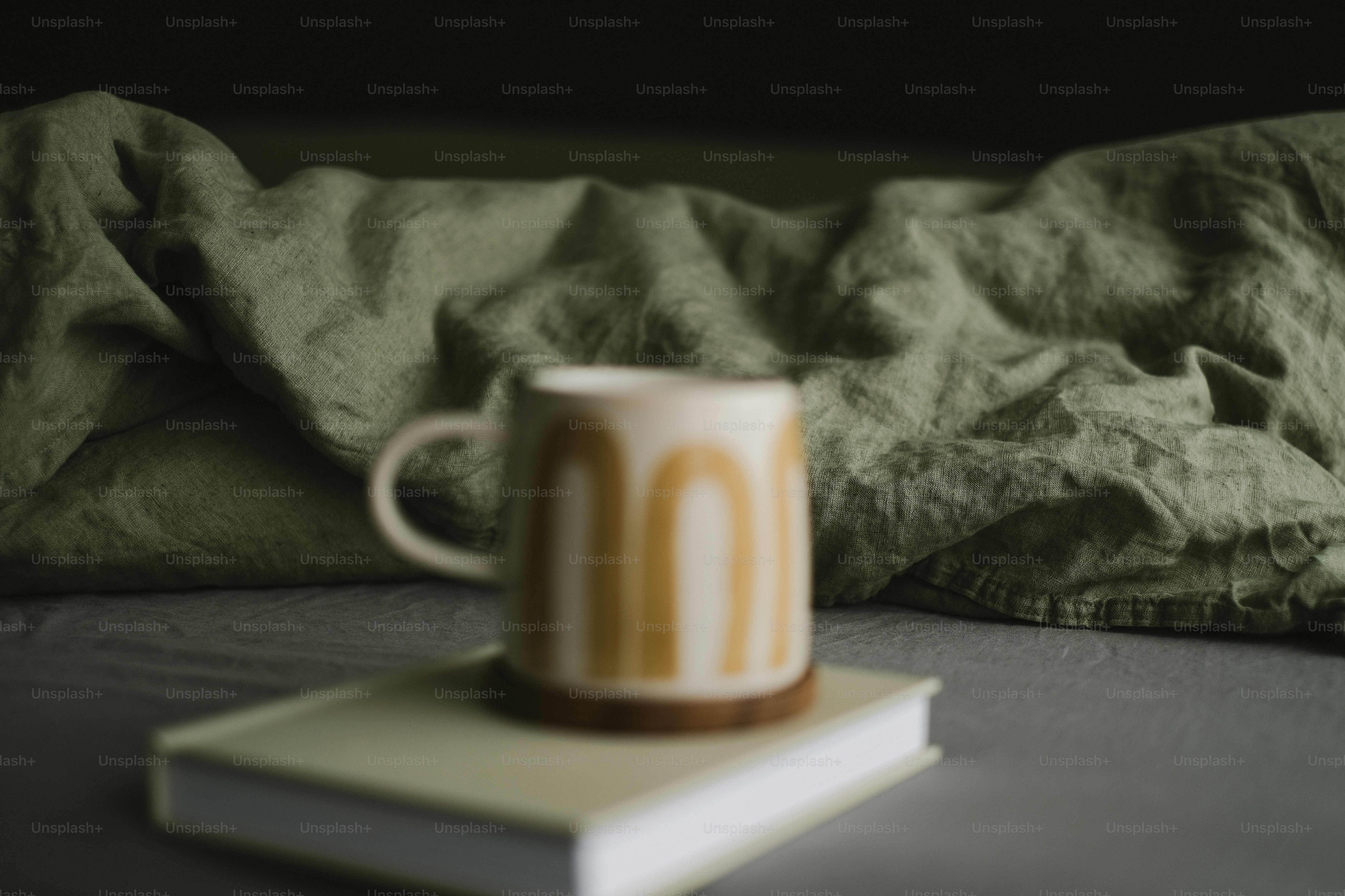 毛布付きの本にアーチ付きのマグカップ