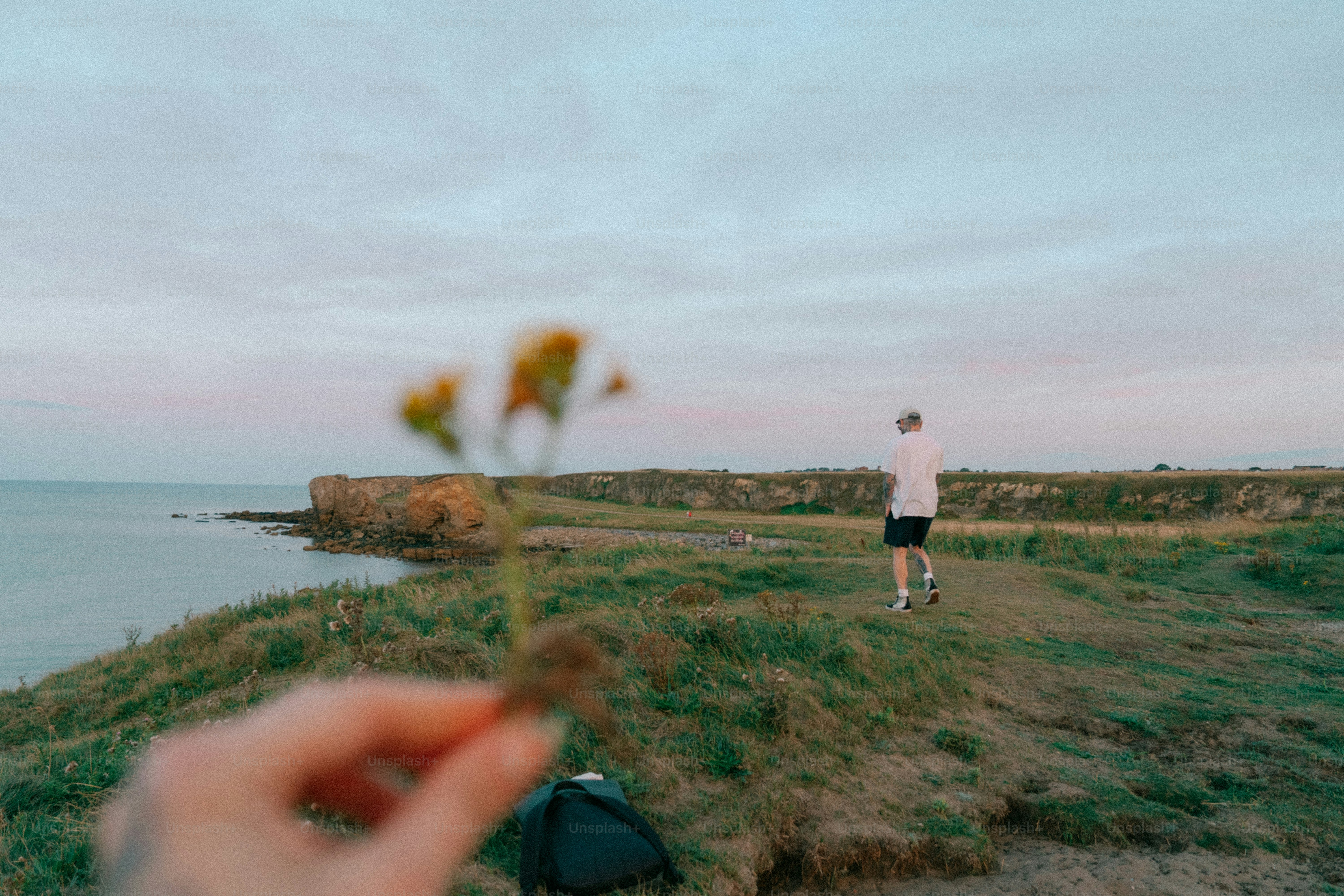 Person running by the ocean with flower