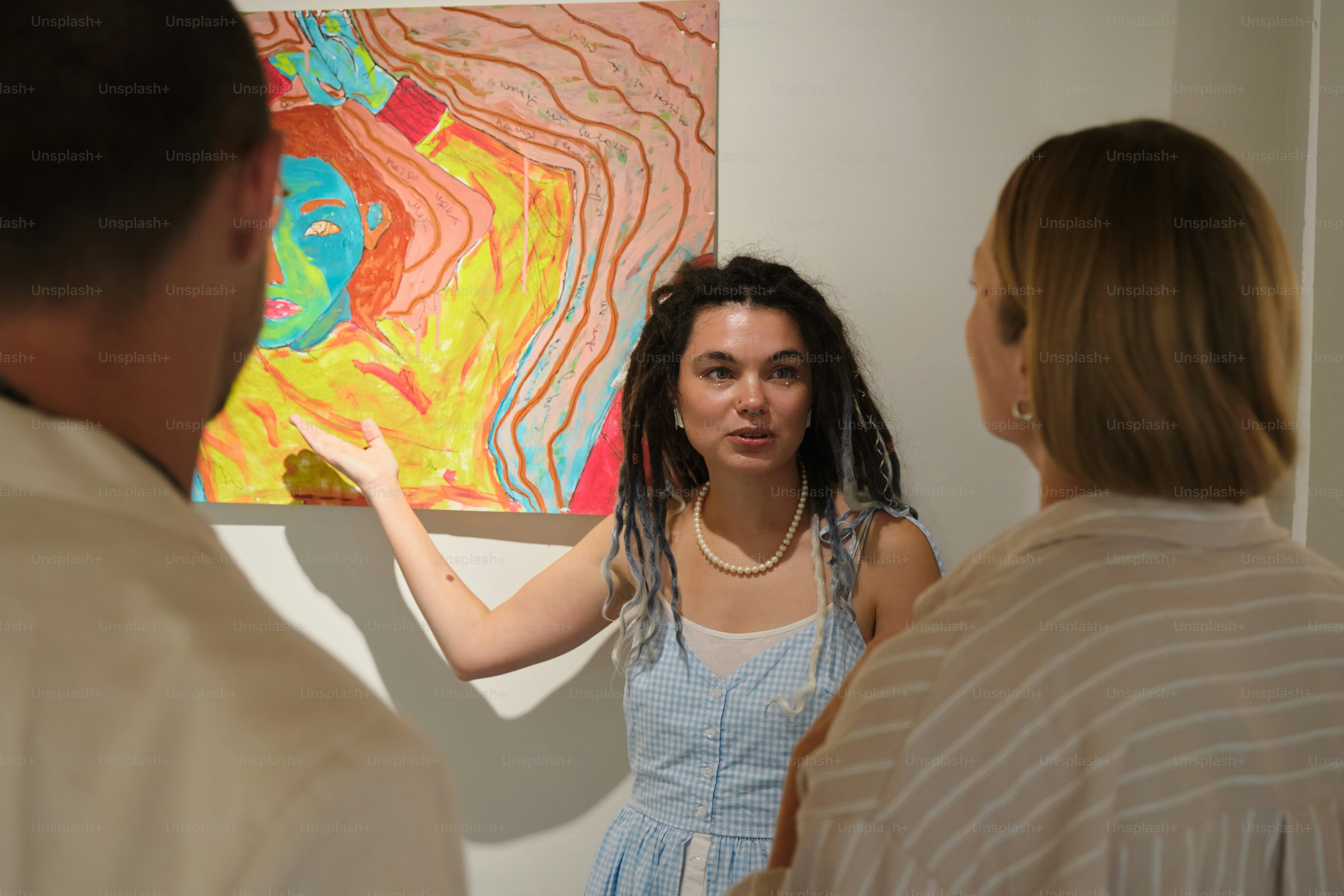 Artist explains colorful abstract painting to visitors photo – Art ...