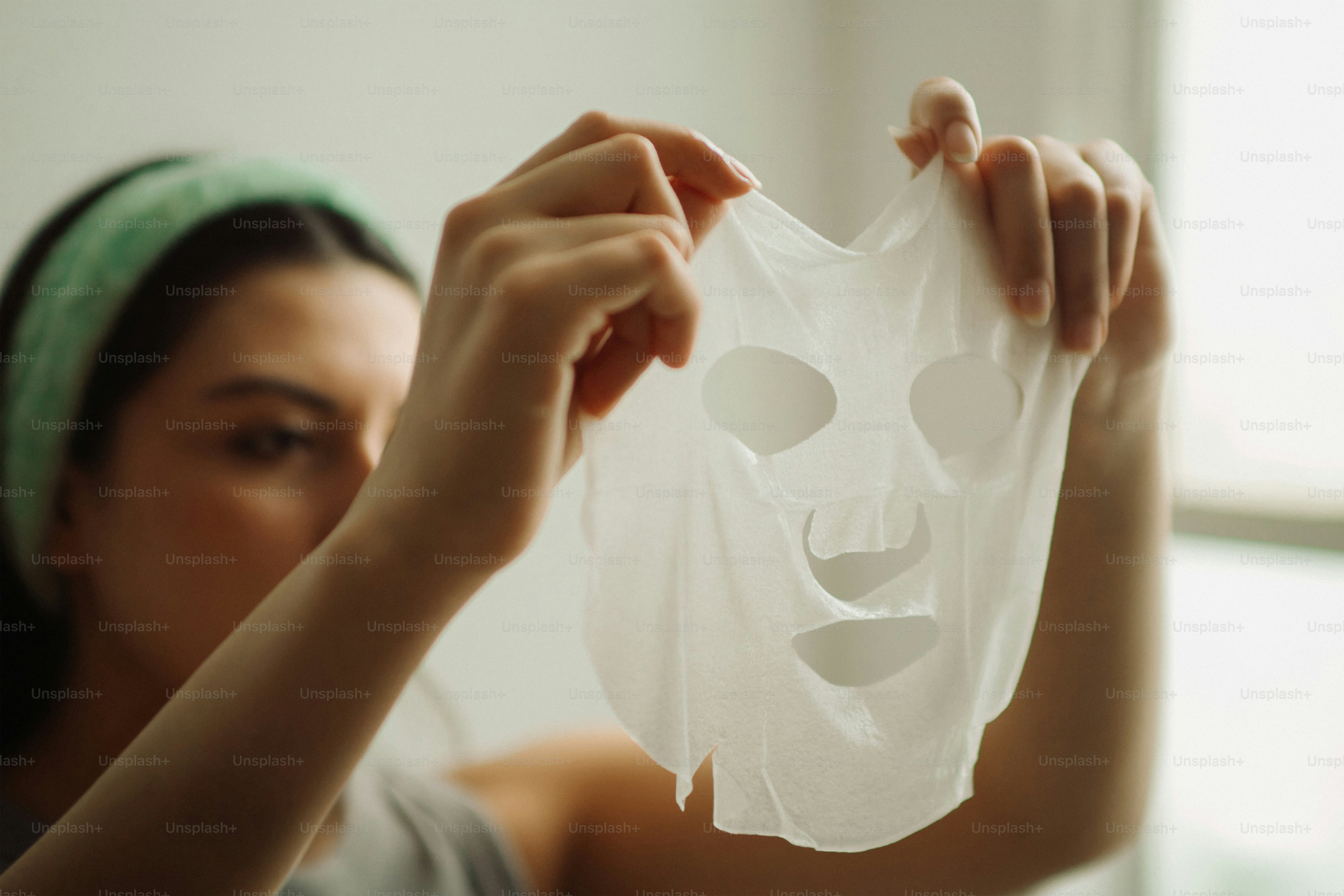 Woman holding a white sheet face mask