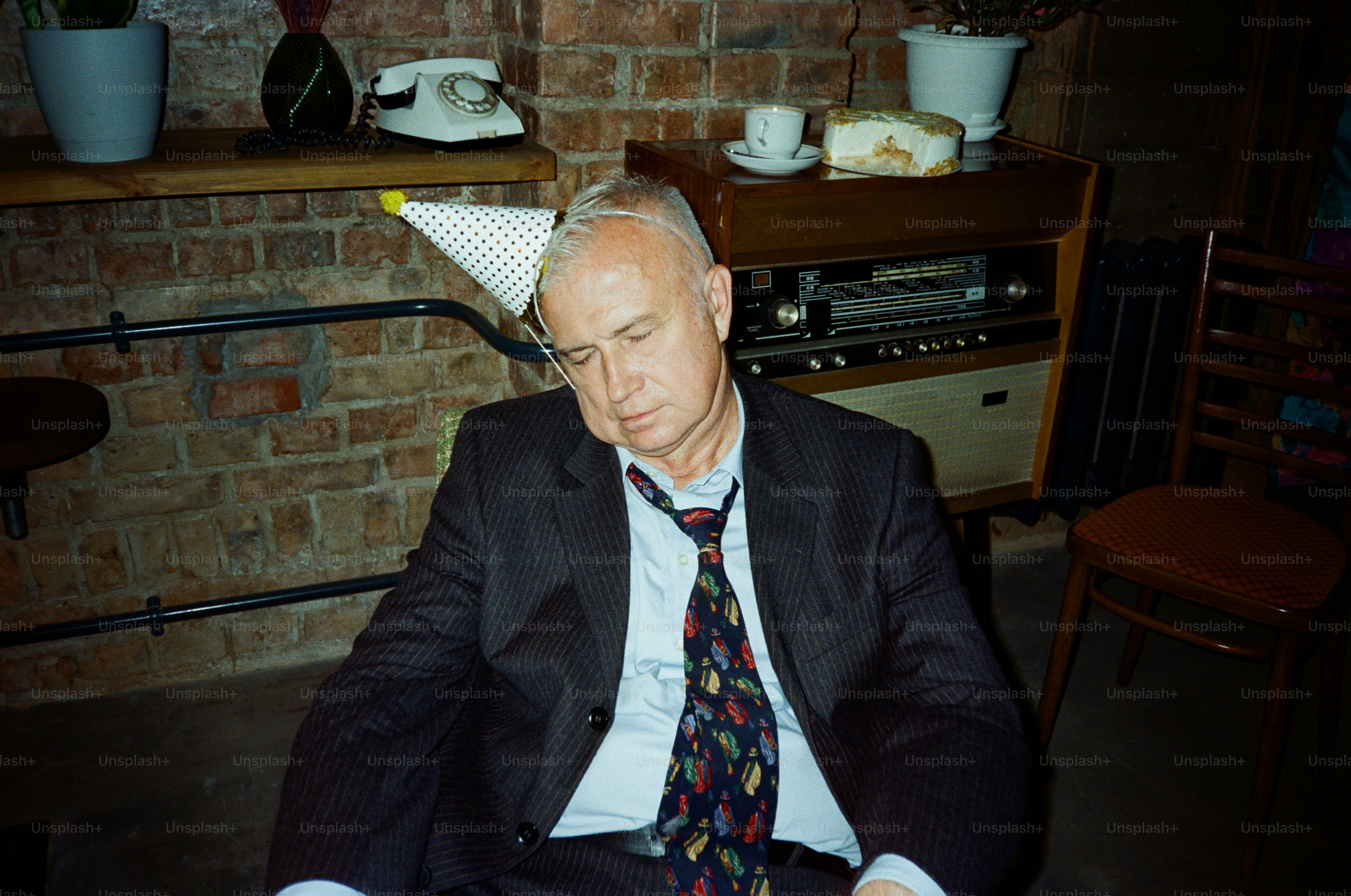 Man in suit wearing party hat asleep