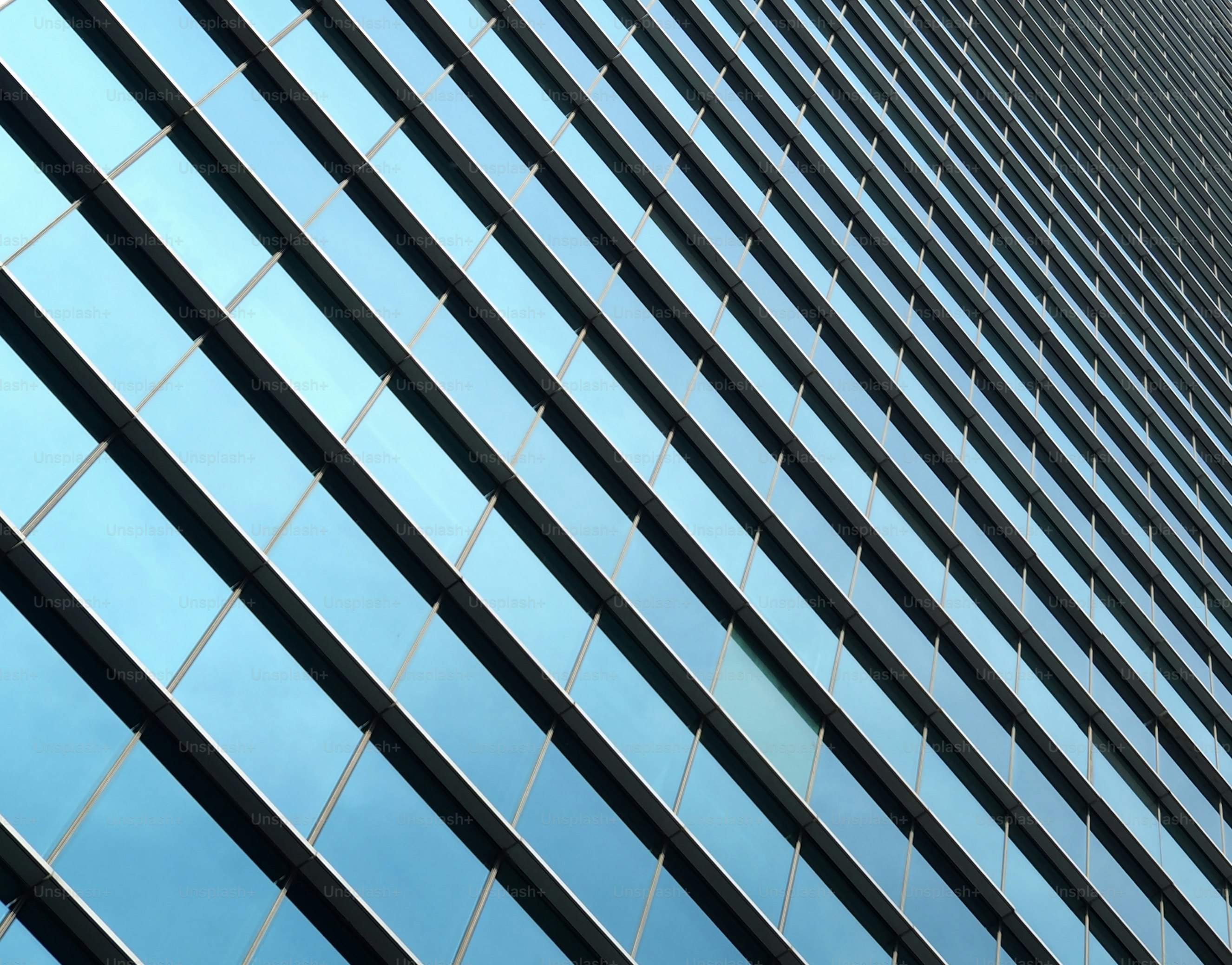 Modern glass building facade with blue sky reflections