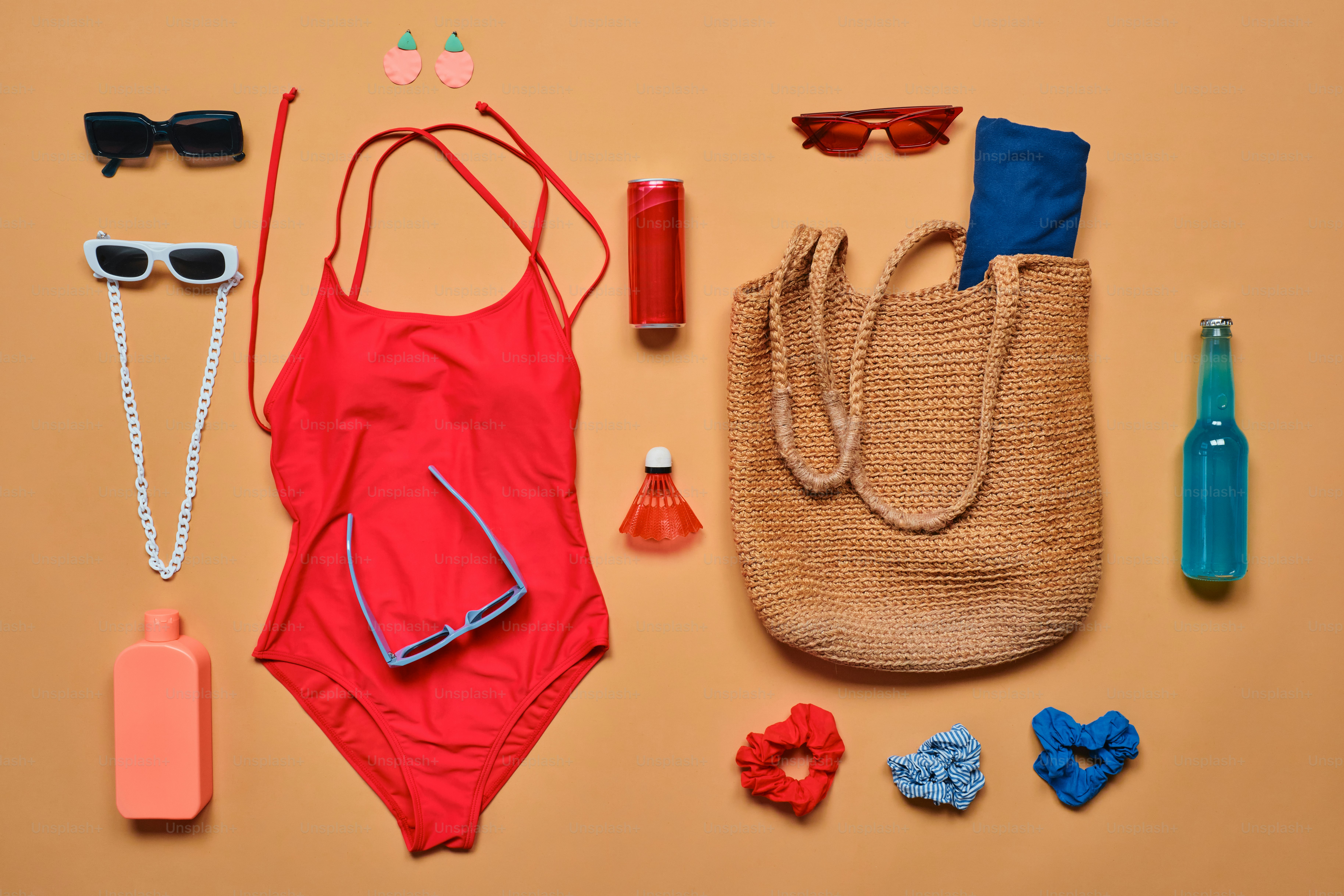 Red swimsuit and beach accessories laid out flat.