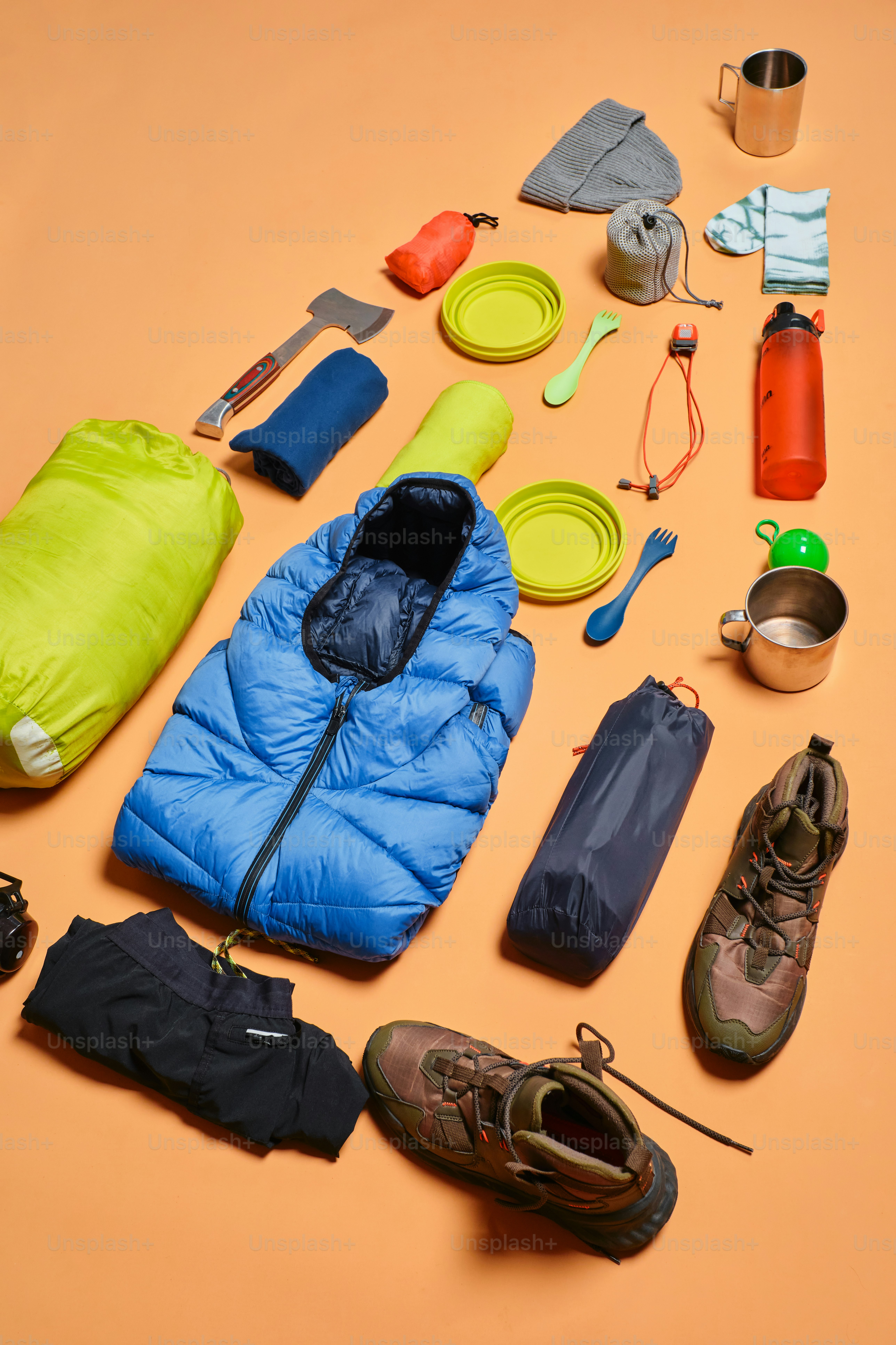 Camping gear arranged on an orange background.