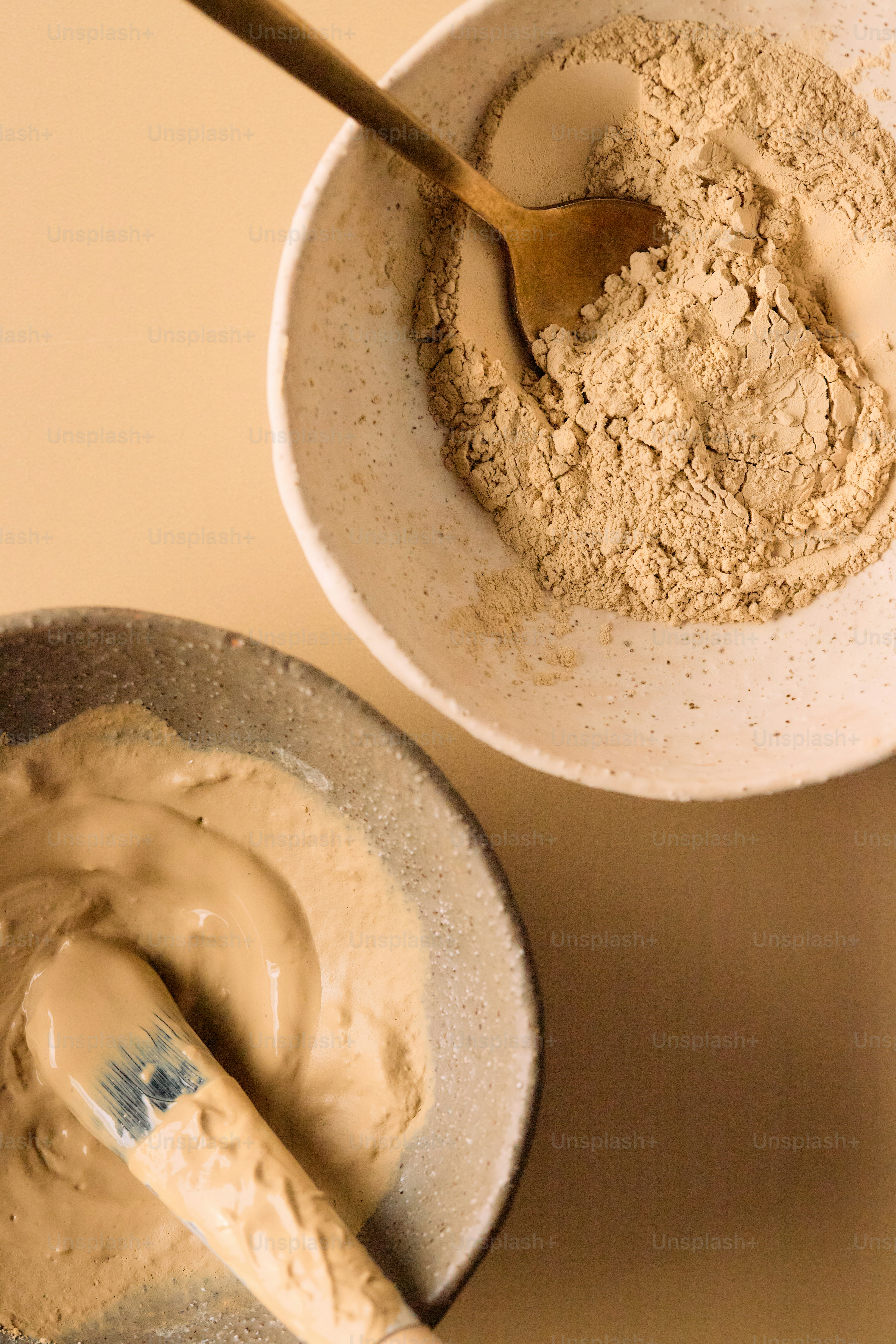 Two bowls with clay mask ingredients and preparation