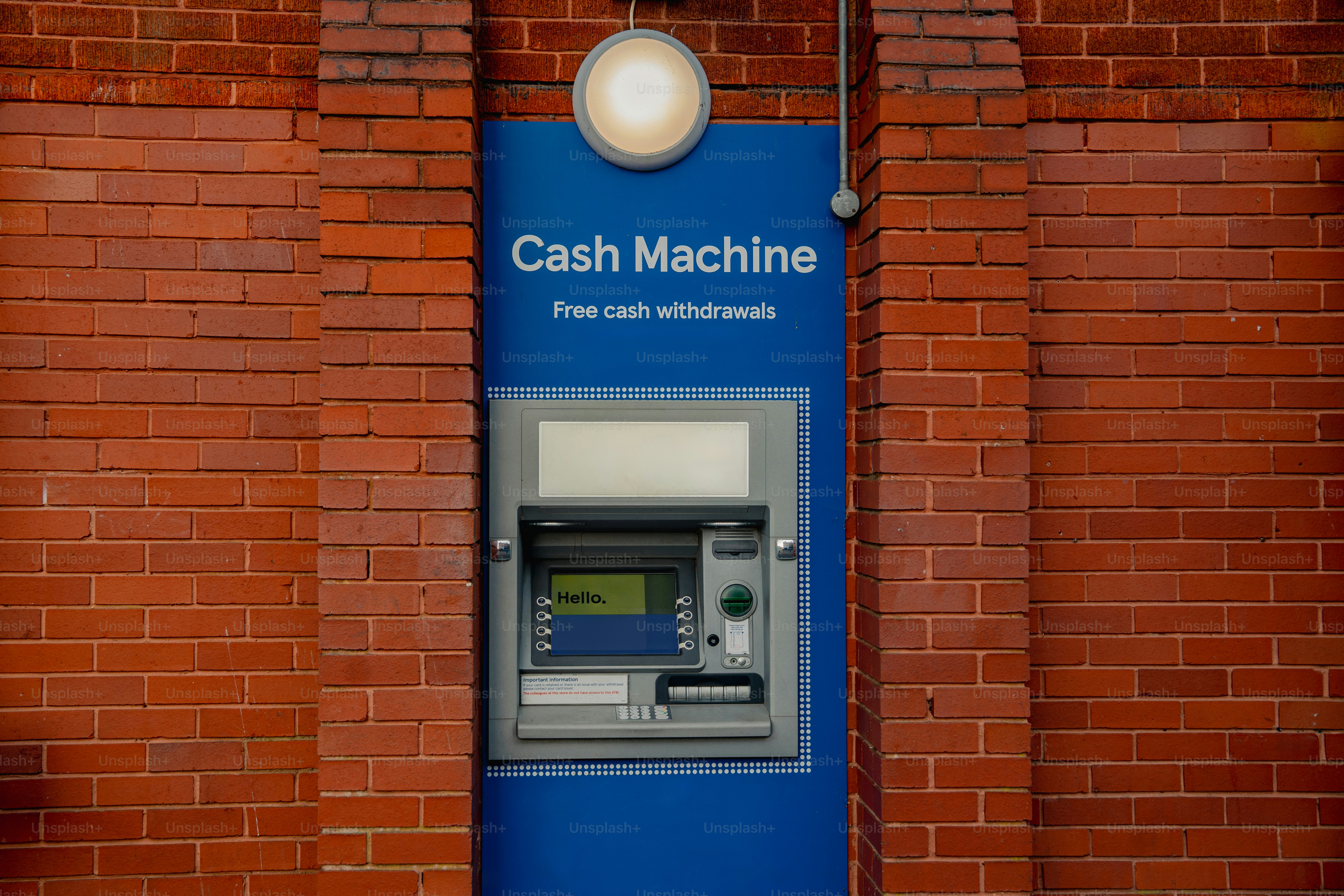 A cash machine mounted on a brick wall