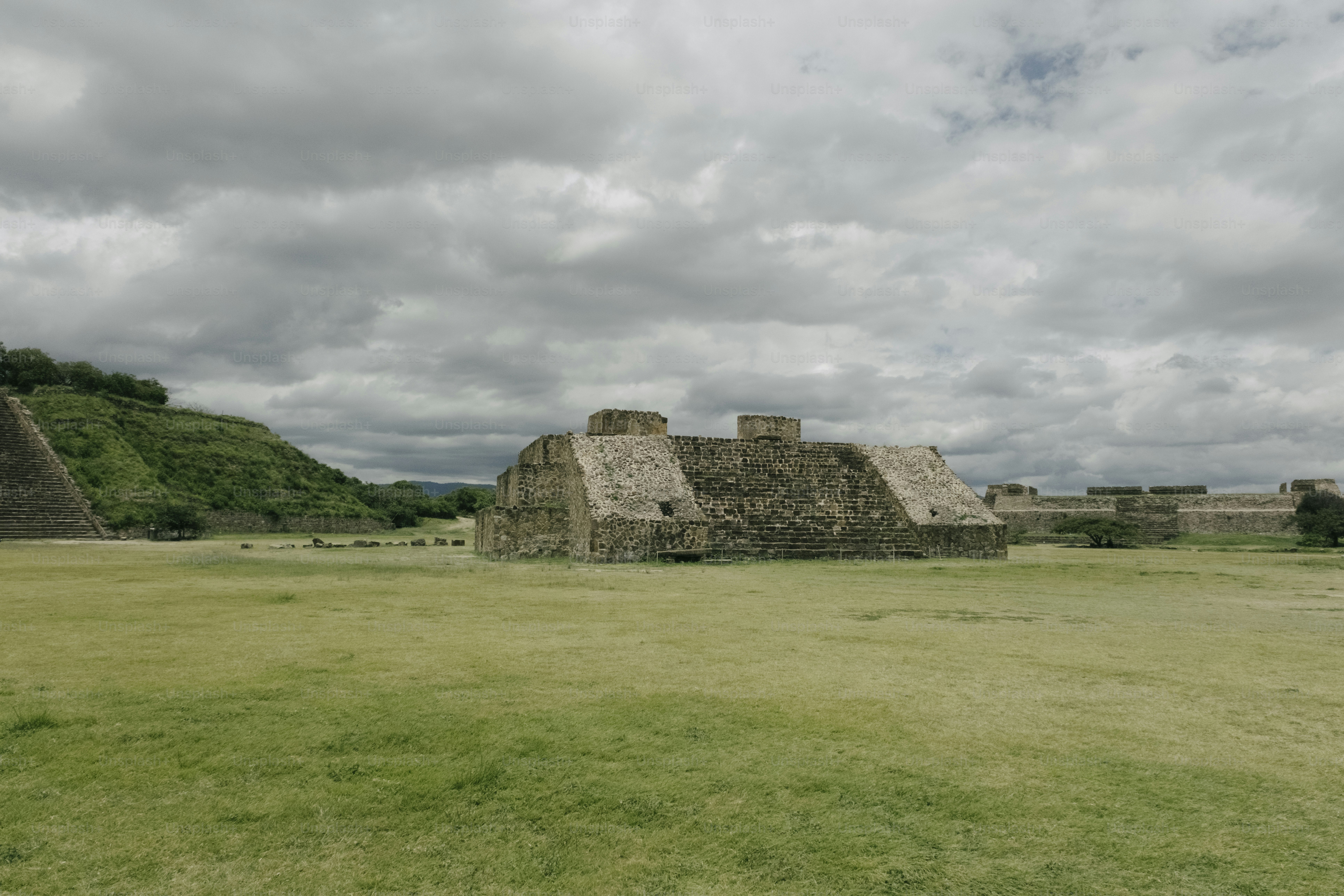 Ancient stone structures on a grassy field under clouds