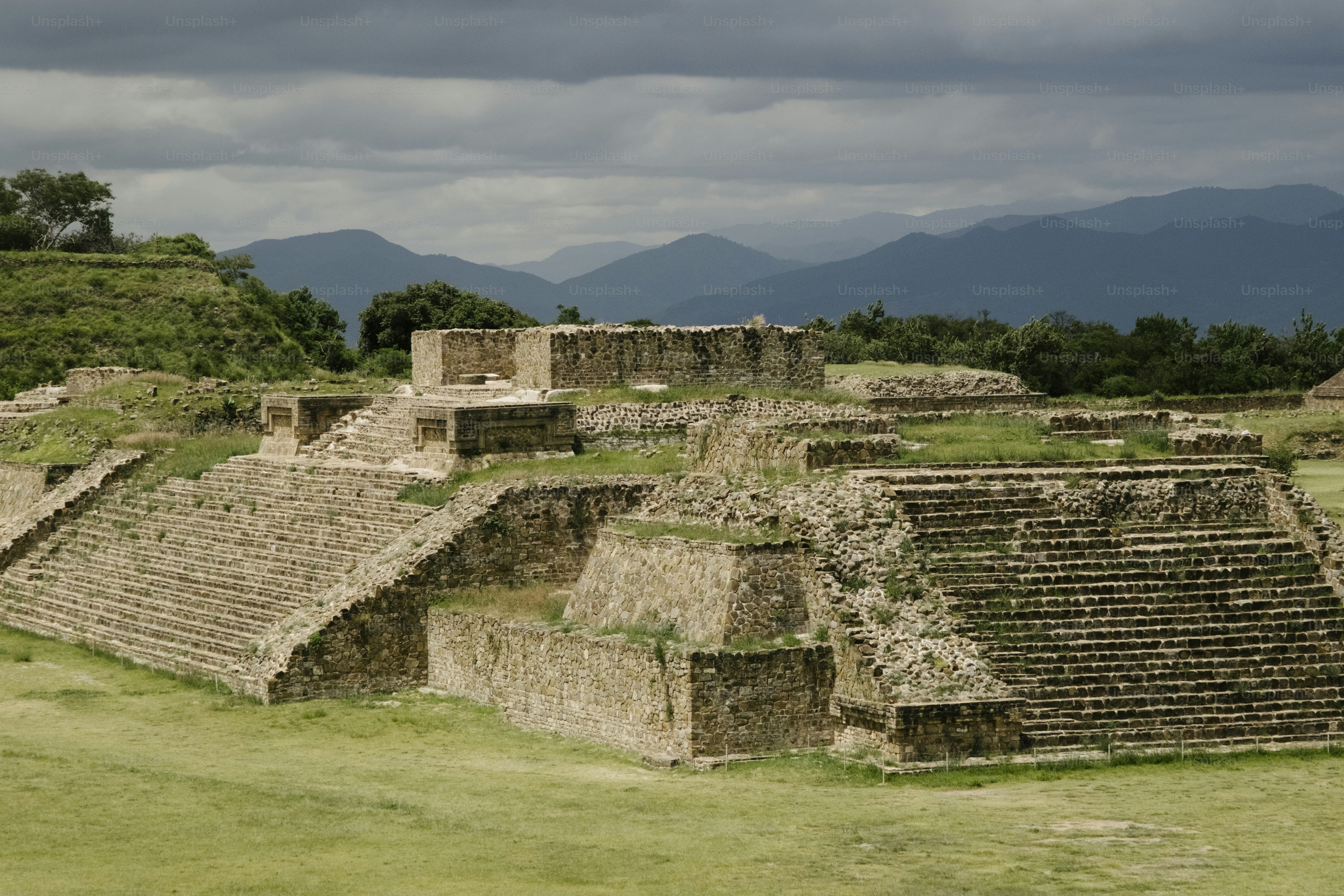 Ruínas de pedra antigas com colinas e montanhas gramadas.