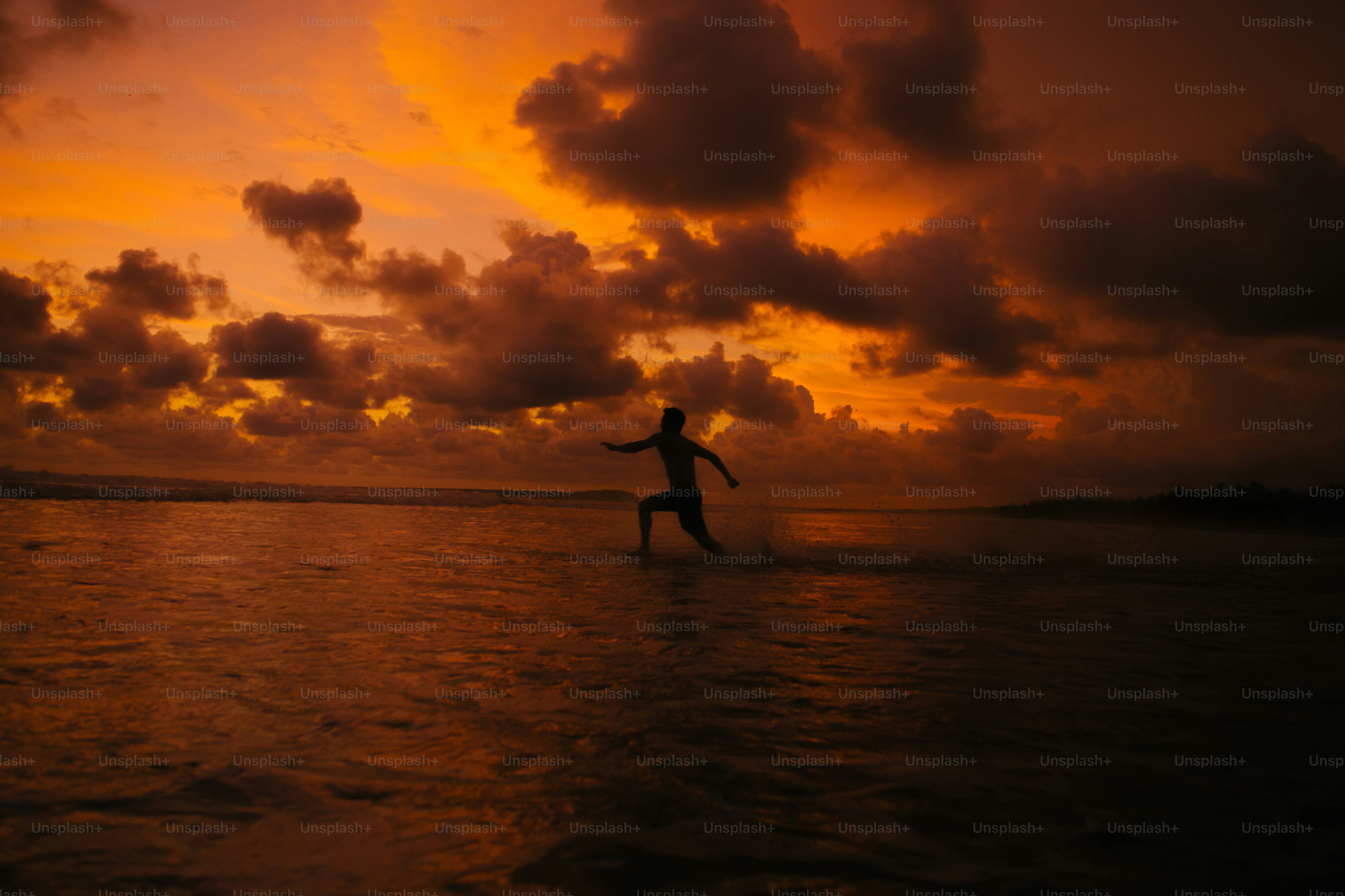 Silhouette of person with arms raised at sunset photo – Sunset Image on ...
