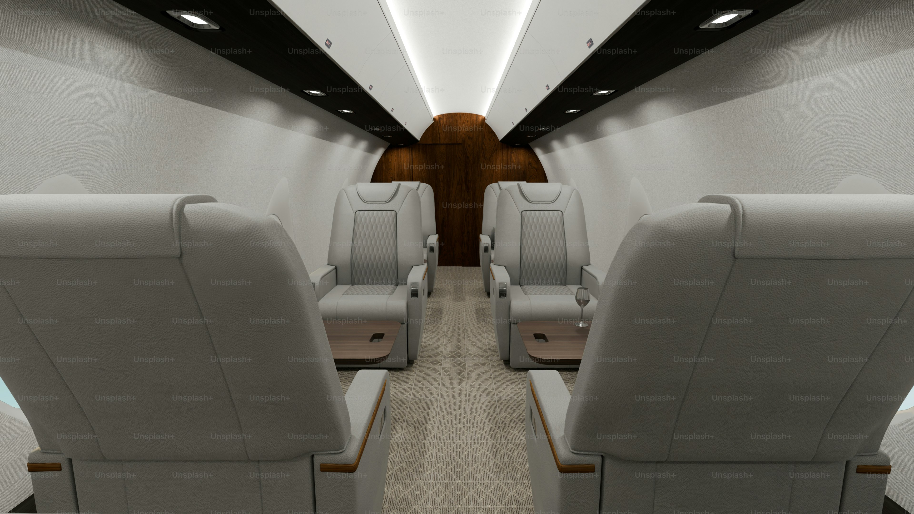 Luxurious private jet interior with white leather seats.