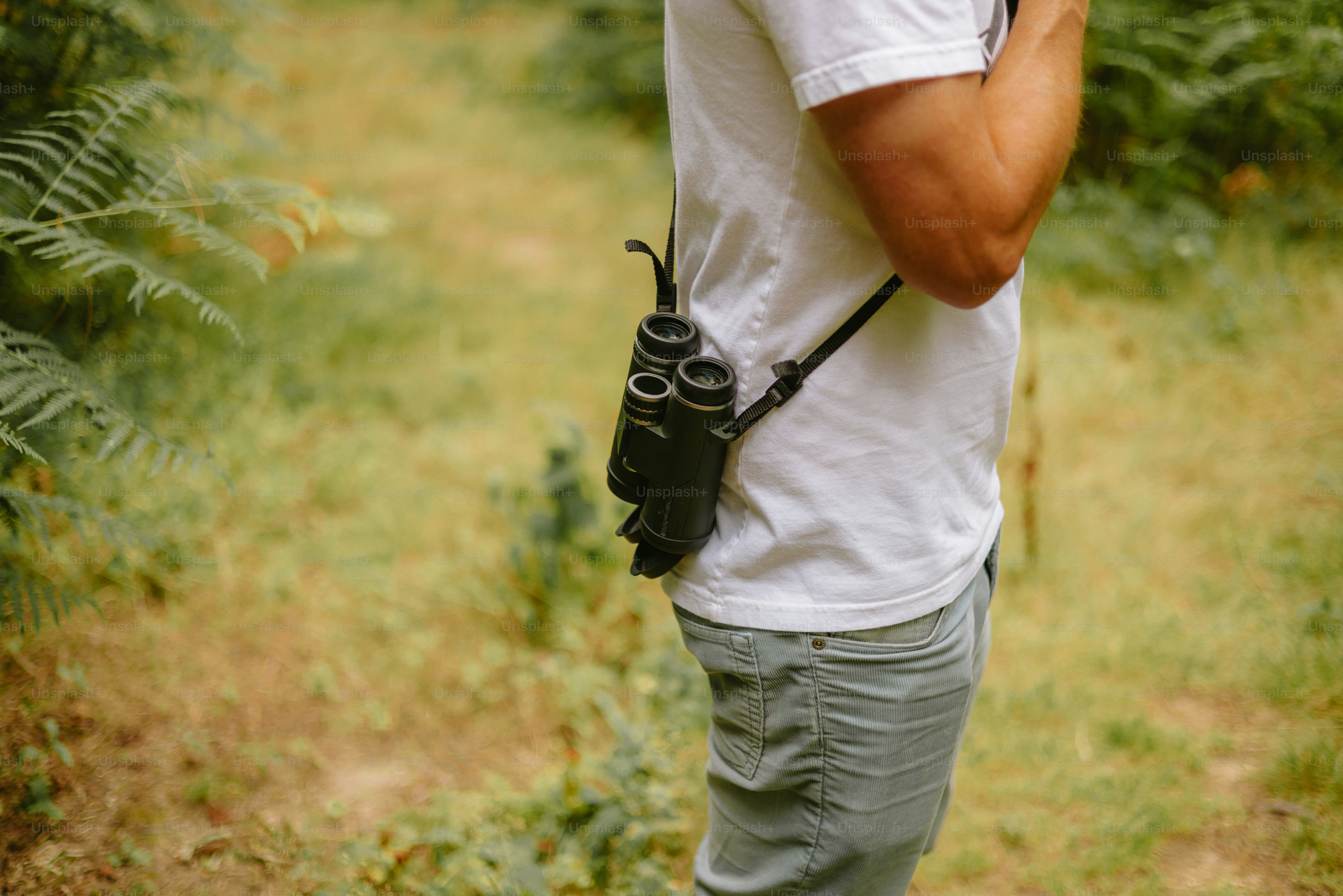 Man wearing binoculars in a forest