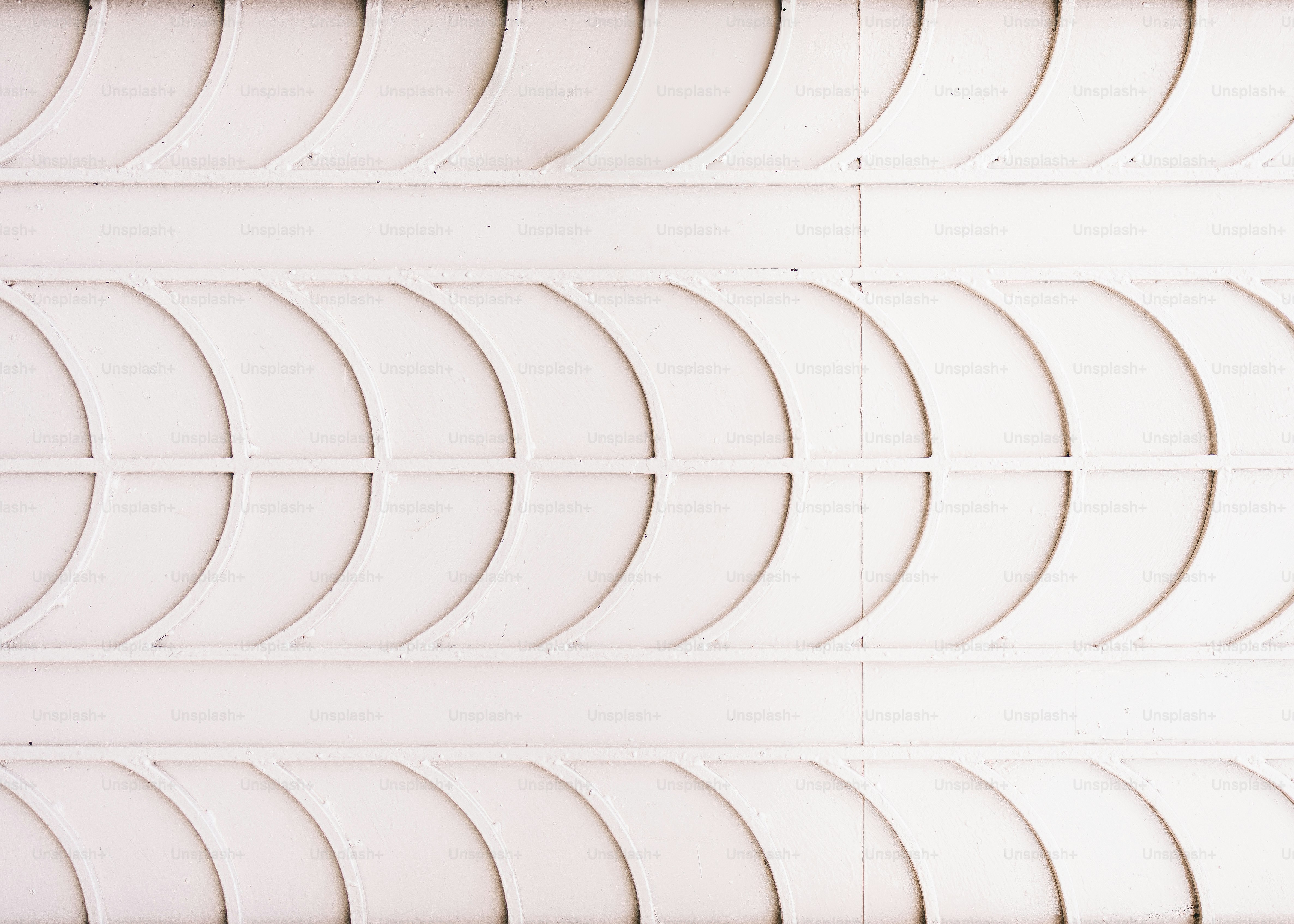 White textured wall with repeating curved patterns