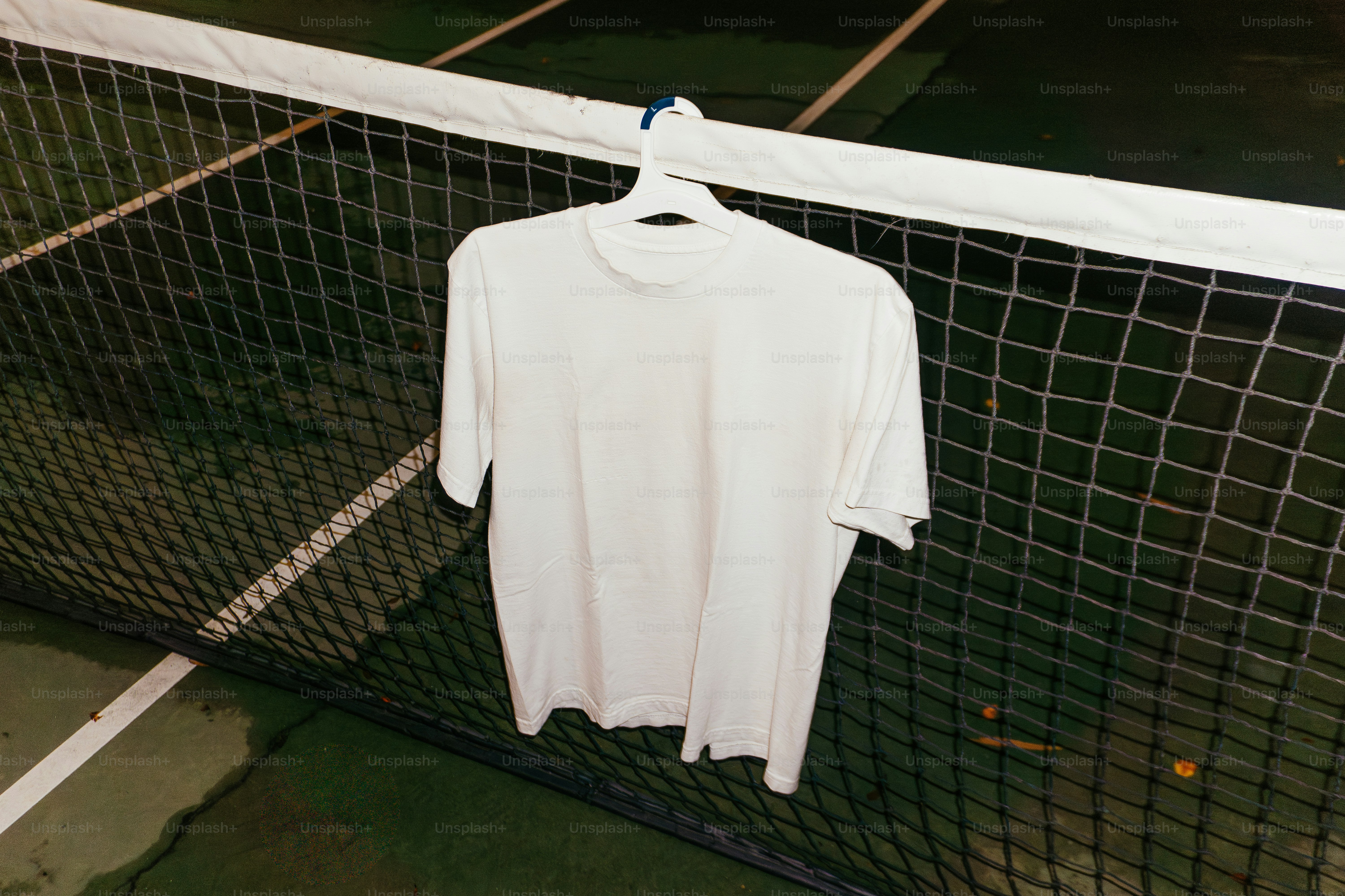 테니스 네트에 걸려 있는 흰색 티셔츠.