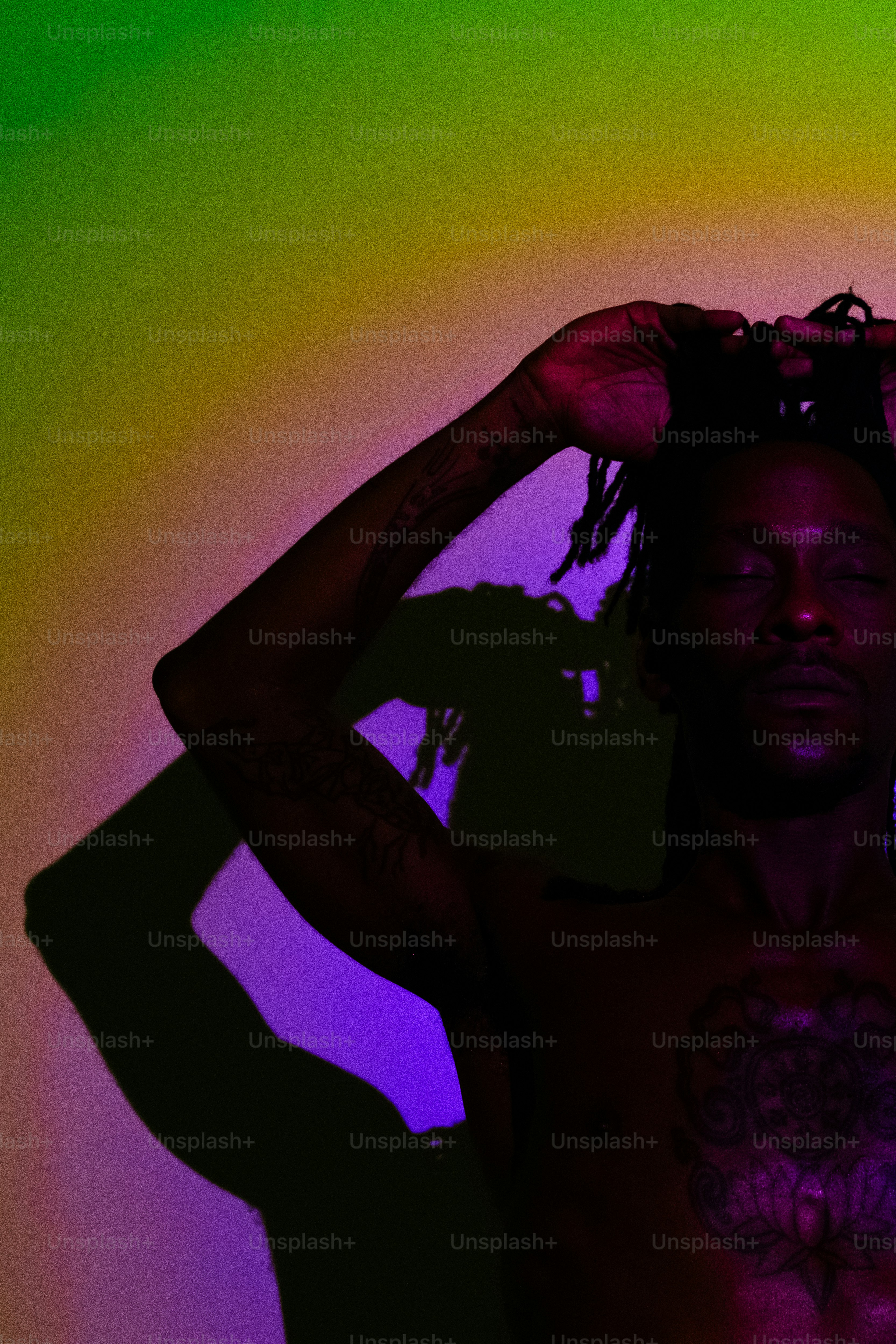 Man with arms raised against colorful gradient background photo ...