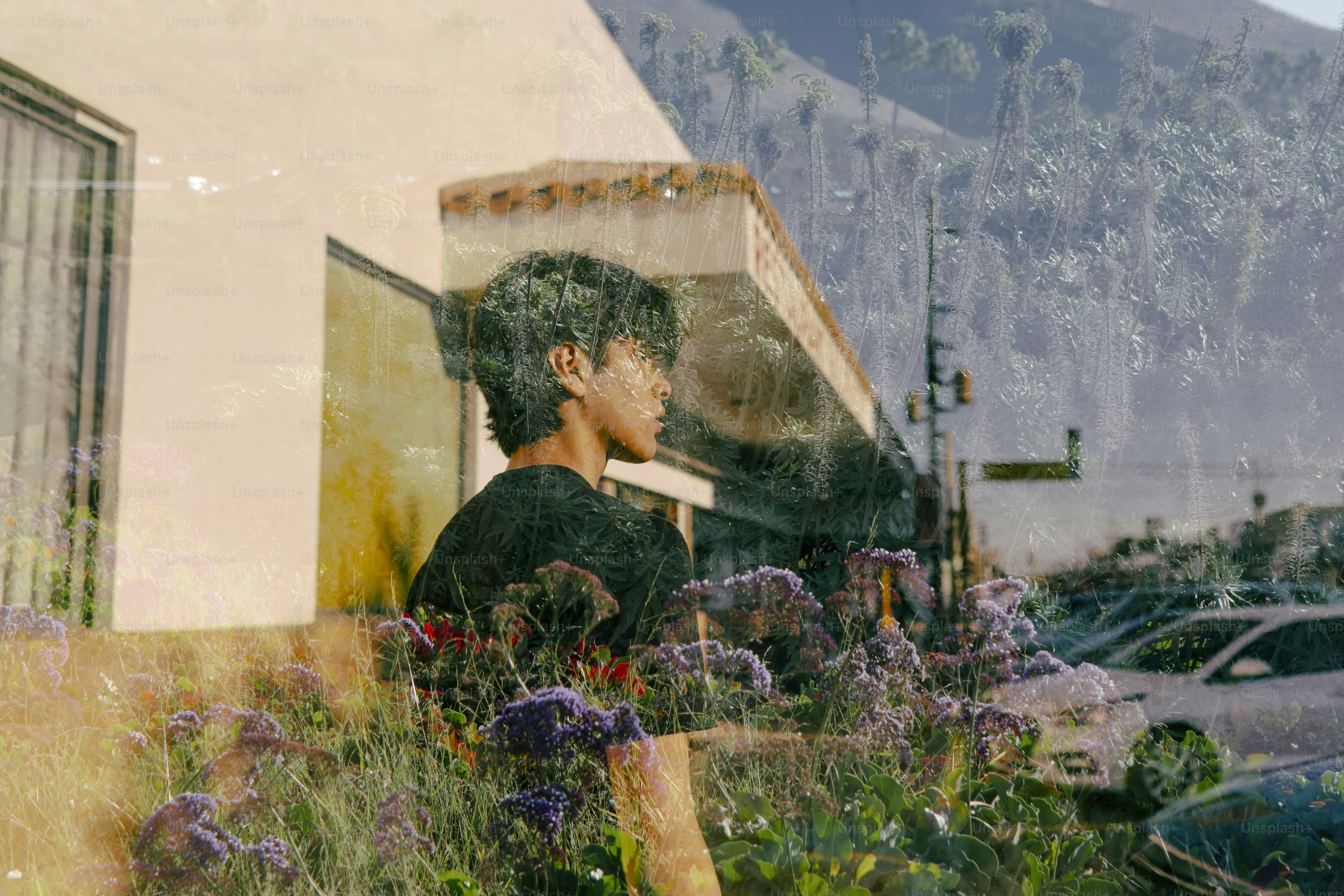 Young man in black shirt with flowers and mountains