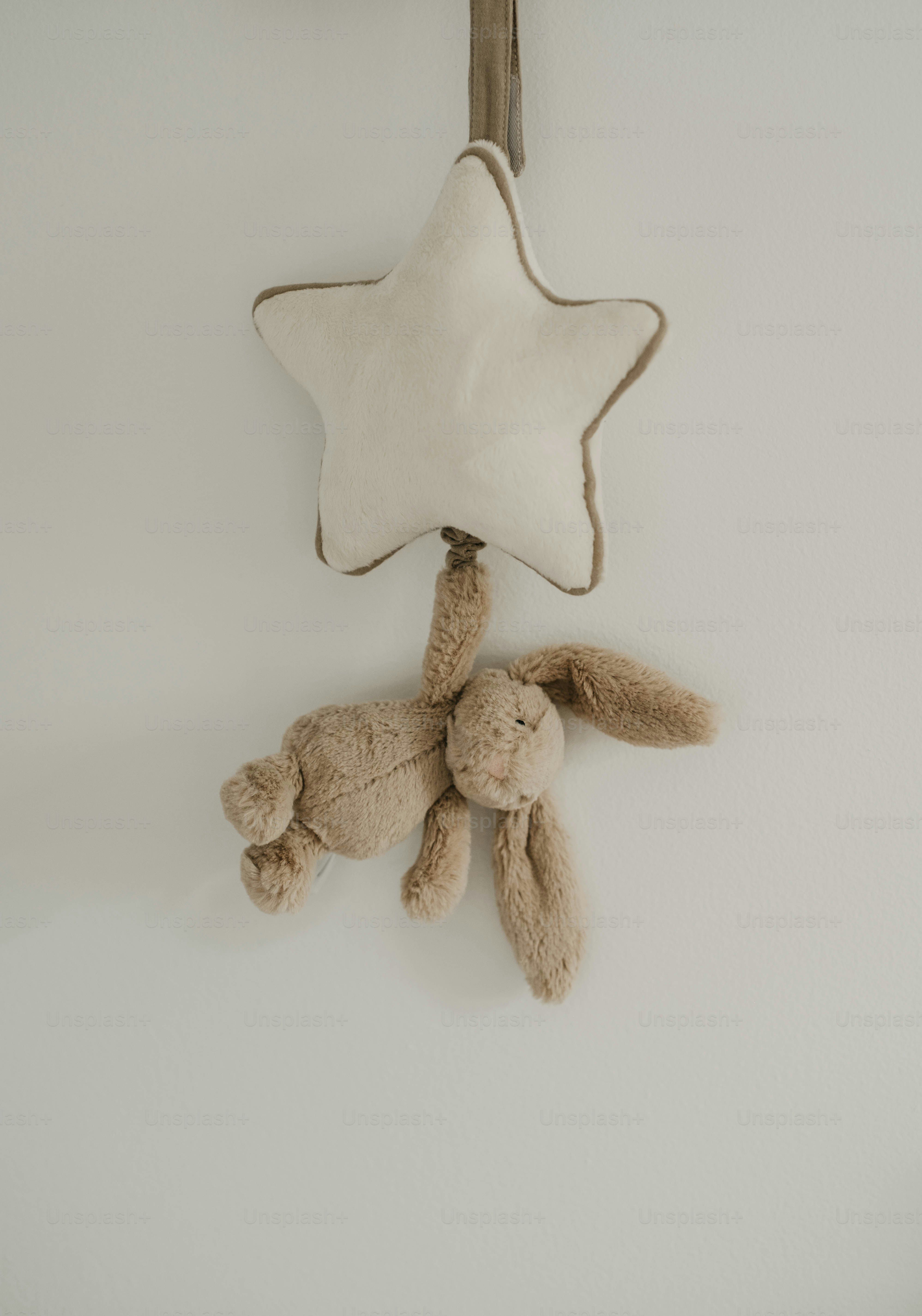 A plush bunny hangs from a star-shaped mobile.