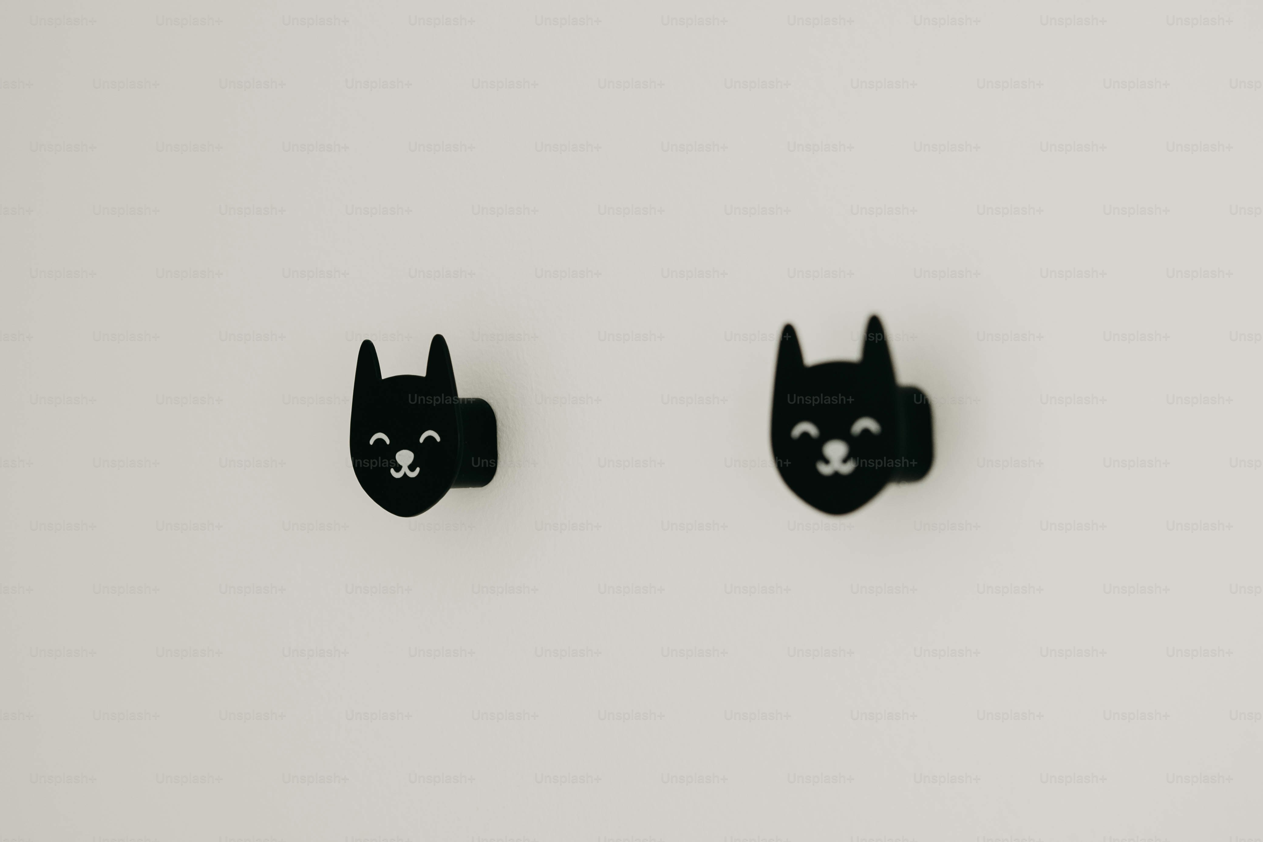 Dua anting-anting wajah kucing hitam dengan latar belakang putih
