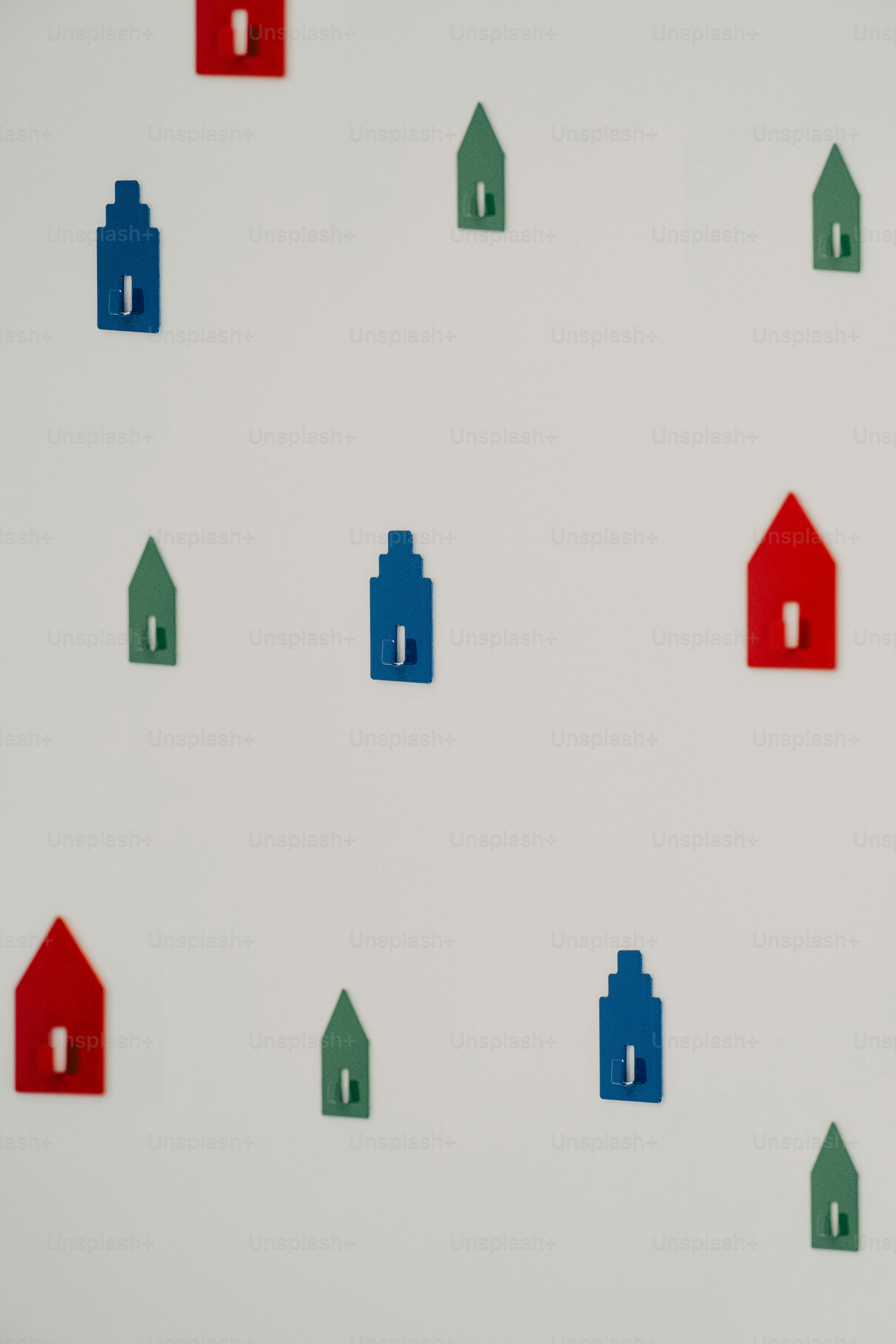 Colorful house-shaped wall hooks on white background