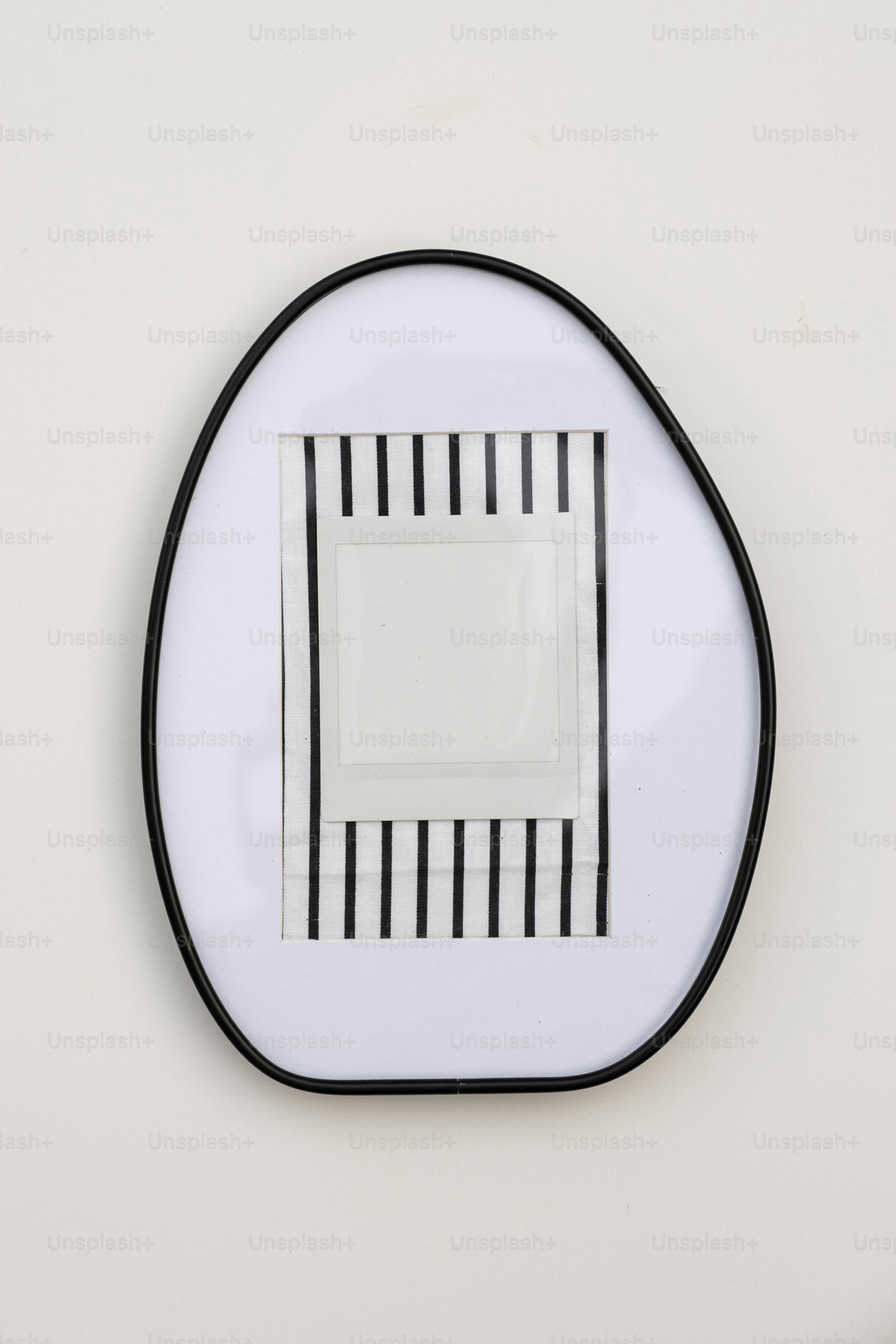 An oval frame with black stripes and a blank photo.