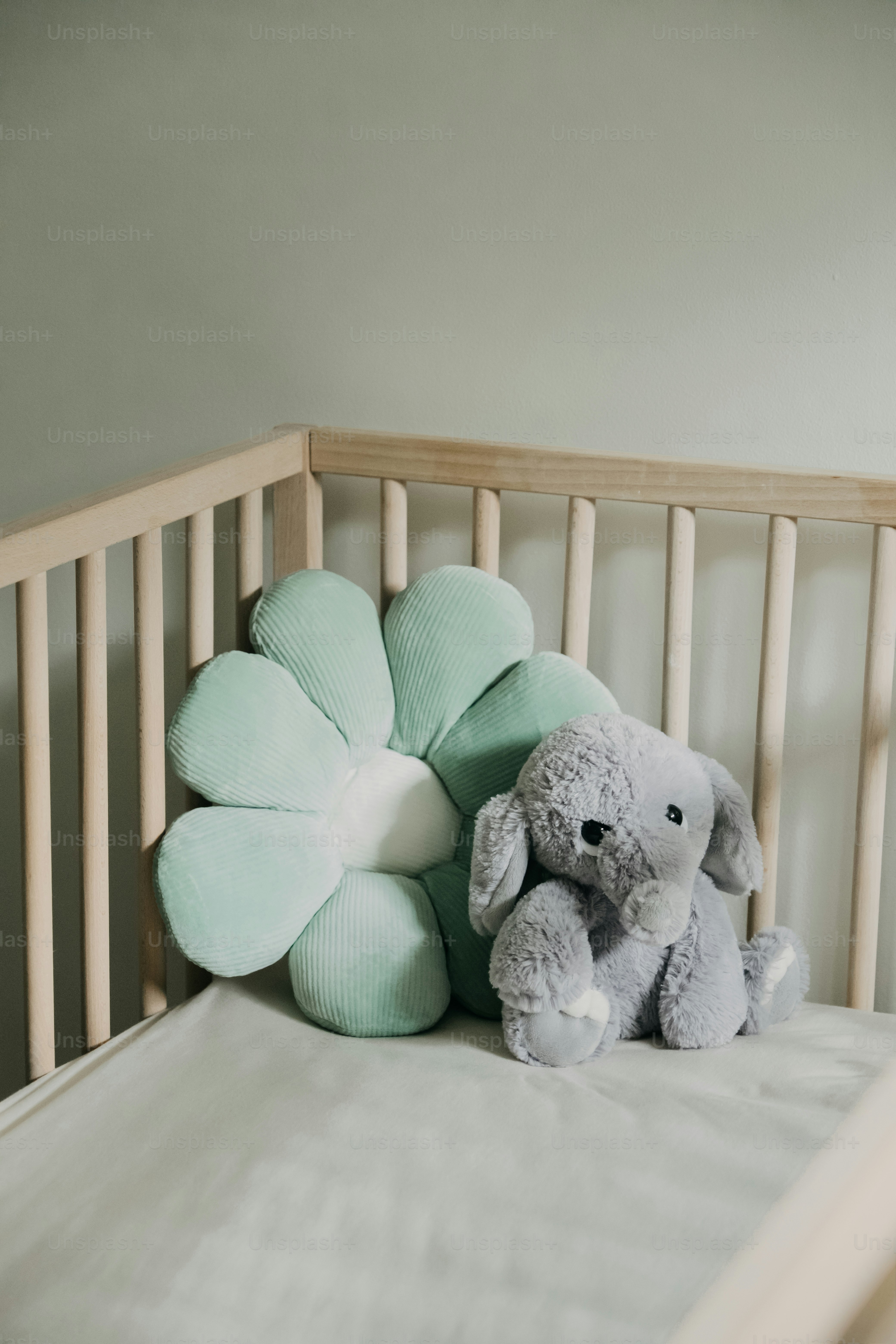 Plush elephant and flower pillow in a crib