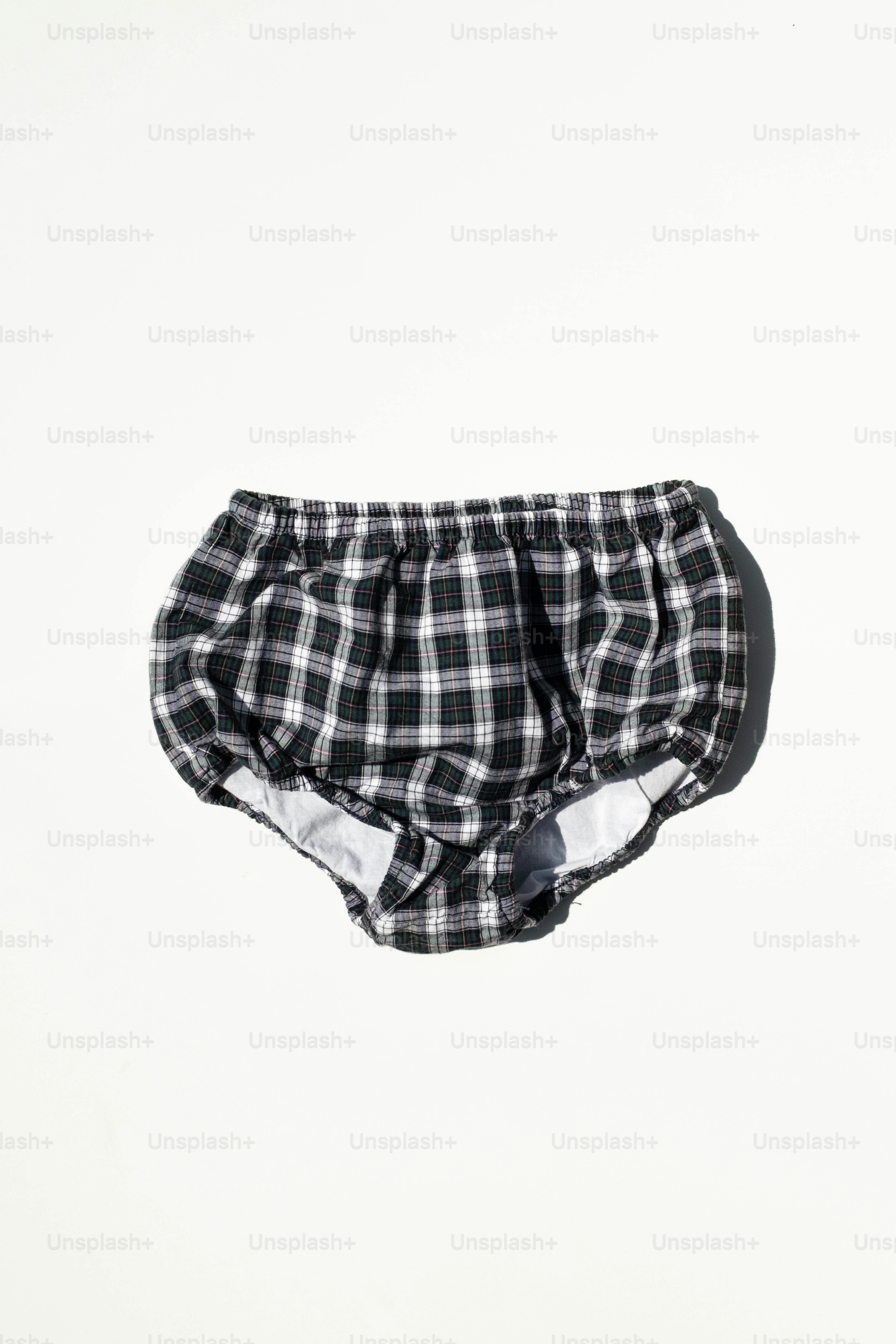 Black and white plaid baby bloomers on white background.